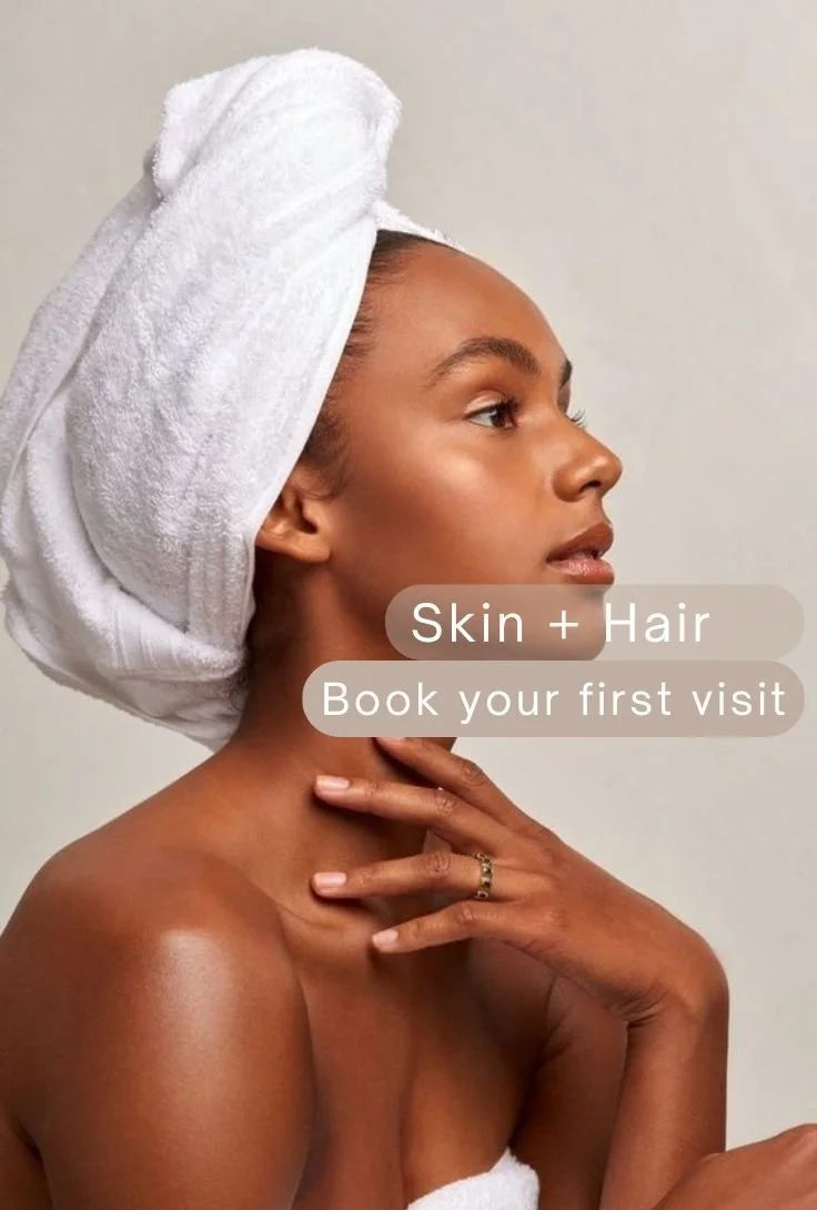 A woman wrapped in a white towel with a towel turban on her head, touching her neck with her hand, promoting skin and hair services.