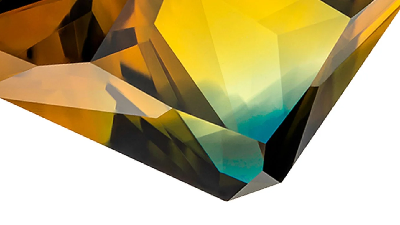 Macro photograph by Cesar Cueva of a faceted Australian parti sapphire, revealing angular planes and colour transitions from golden yellow and amber to green and turquoise.
