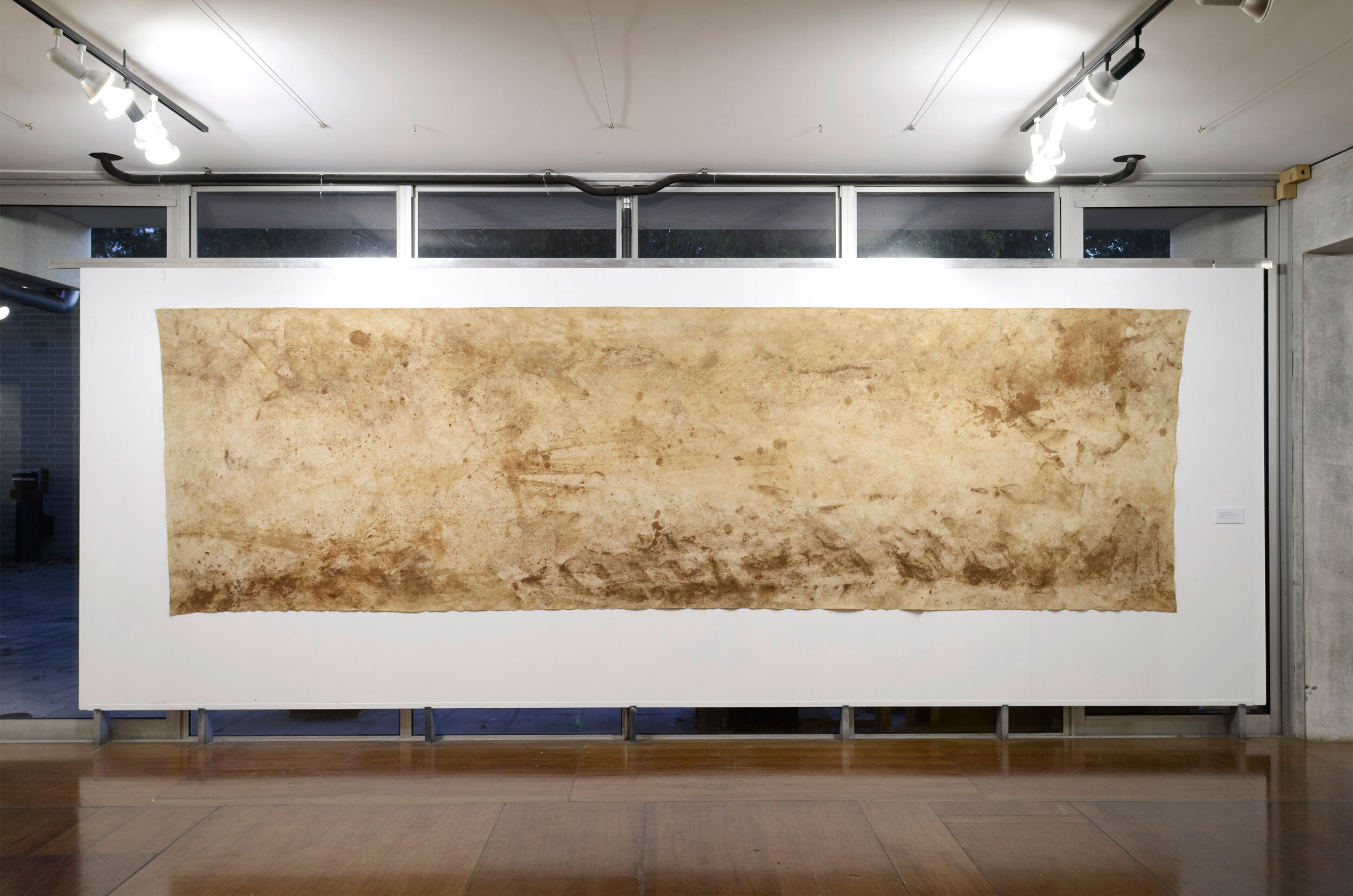 'Work on the Wilkinson’s' (2015), 5500 x 2013 mm, indexical marks, dirt, grass stains, fungicide, methyl cellulose on canvas, Marks made by Paul Wilkinson, Peter Nalder, Rick Burgess, facilitated by Valdene Diprose, photograph: Dan McCabe