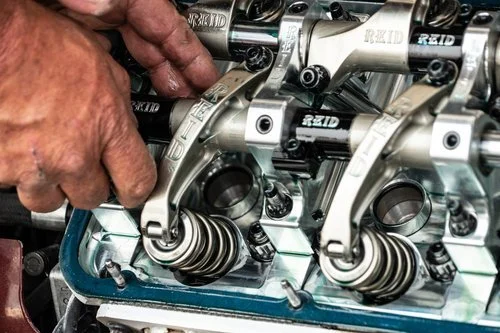 Image of hands grabbing mechanical parts of engine