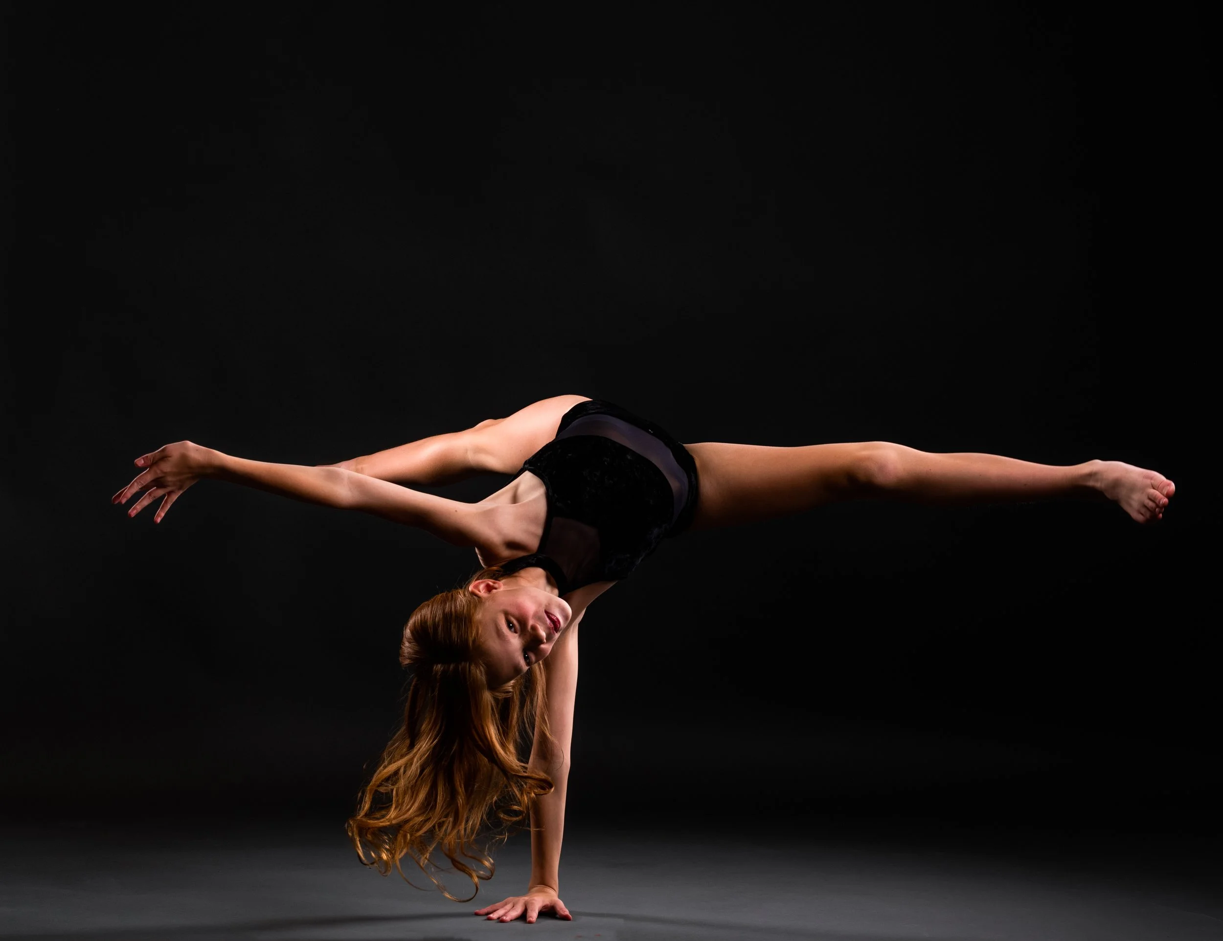 Girl dancer with dramatic one arm hand stand pose