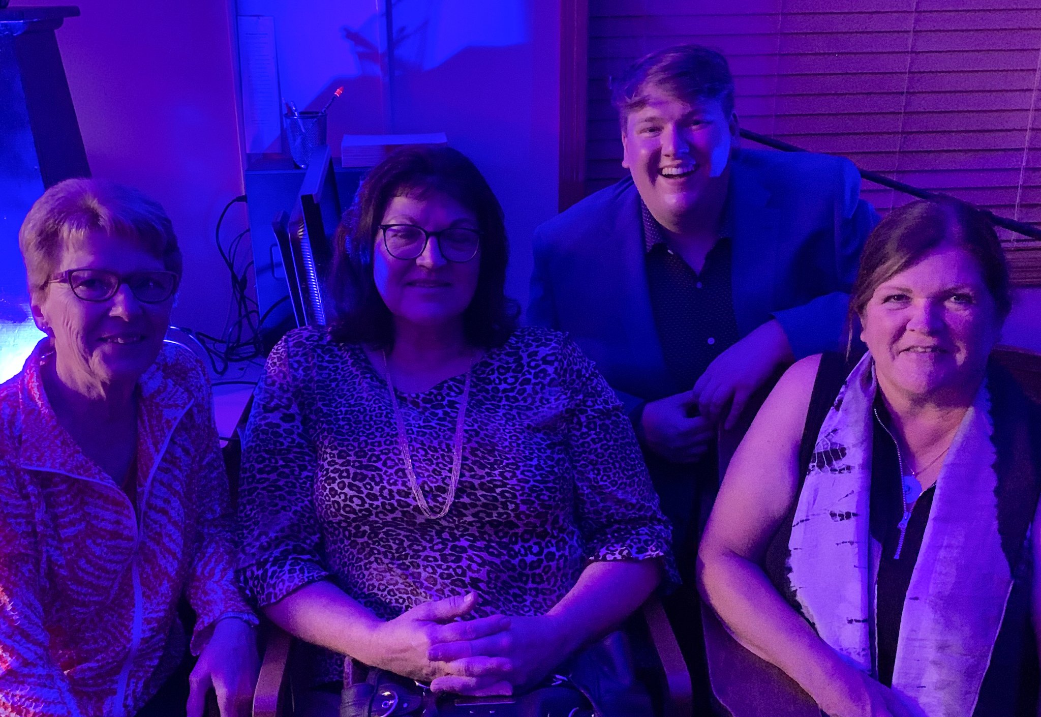 Alex smiles with three of his teachers