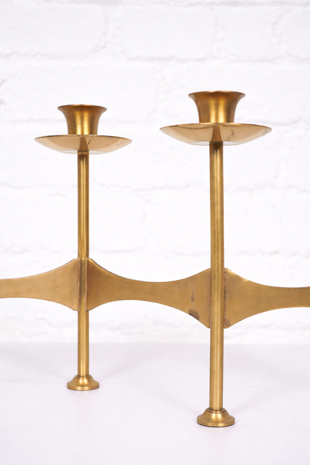 Brass candlesticks against a white wall.png