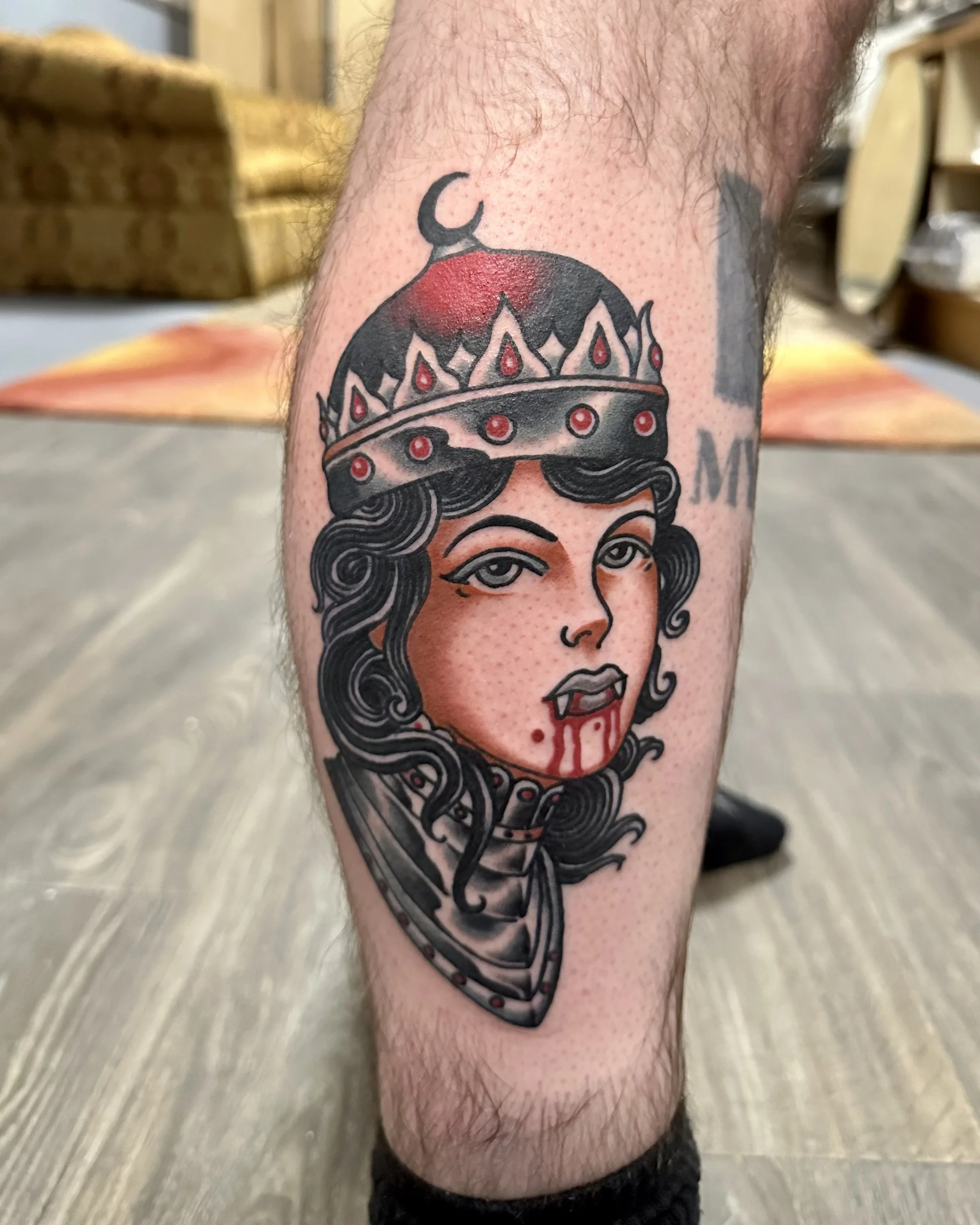 Tattoo of a woman wearing a crown on the person's arm.