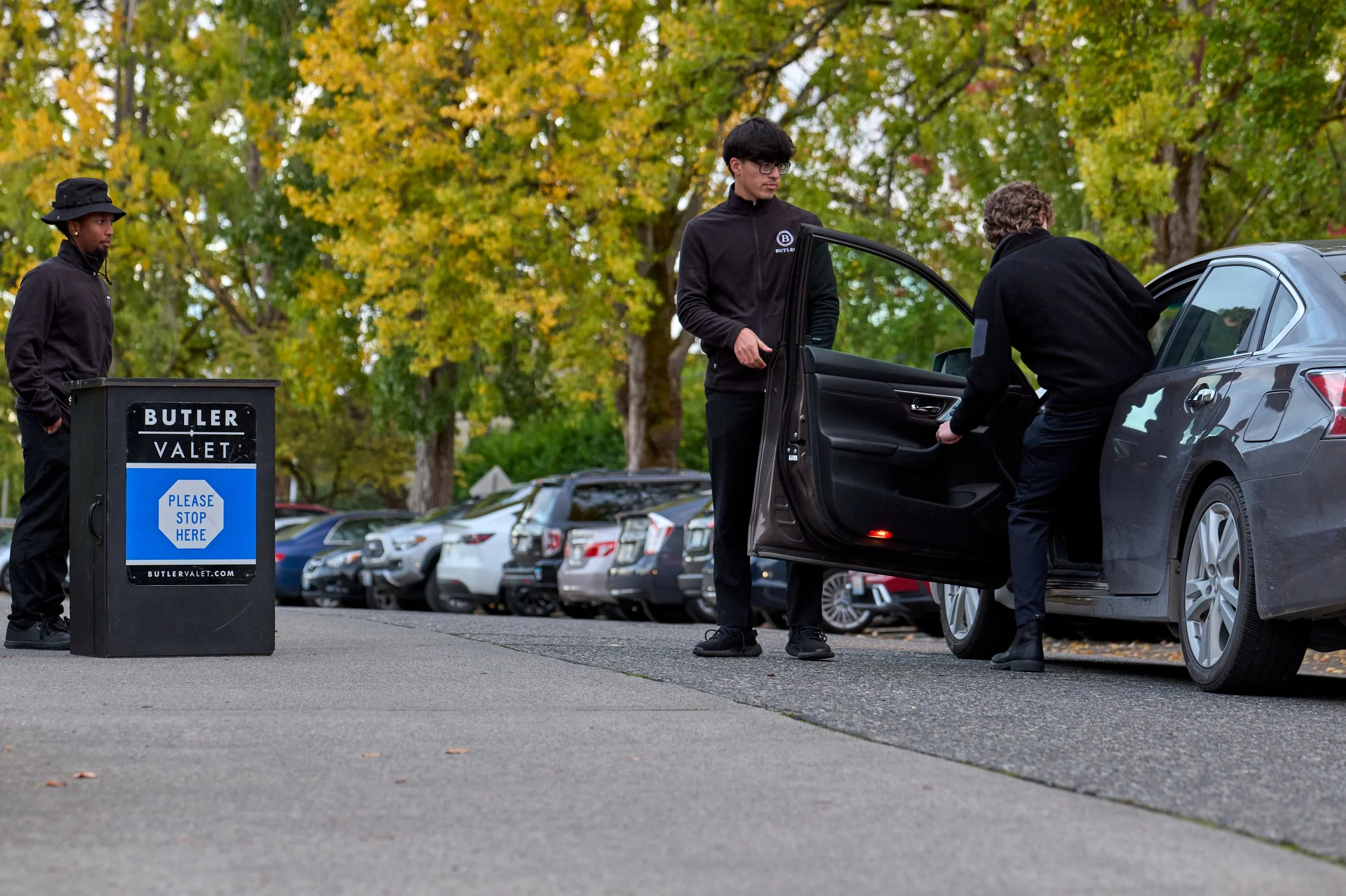 A valet service podium with their staff members in action.