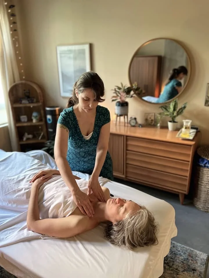 Jennifer Keller, CMLDT performing manual lymphatic drainage with soft, rhythmic strokes on the neck and shoulders to reduce swelling and support lymph flow in her relaxing SoDo, Seattle office.