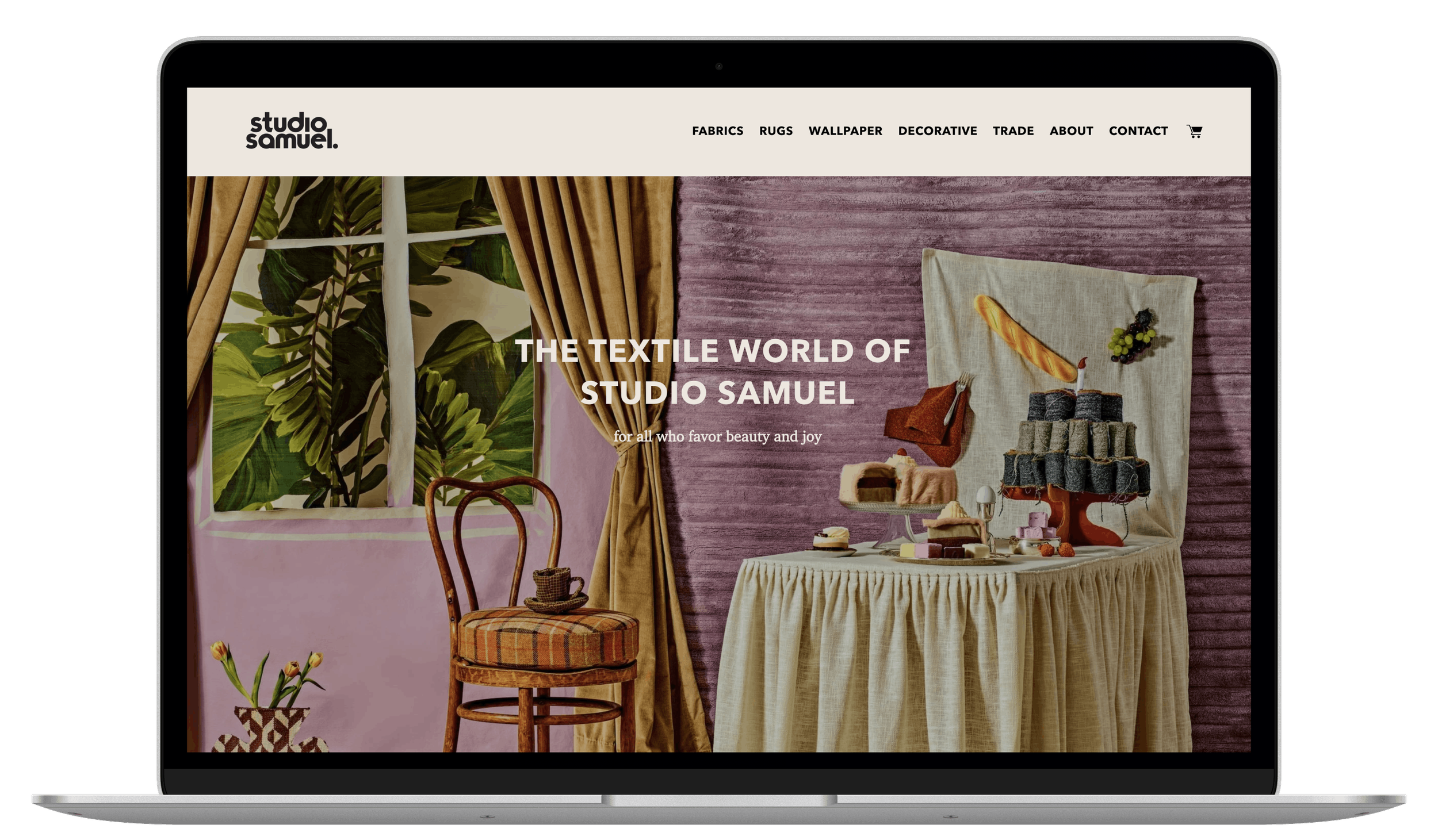 Laptop displaying the homepage of Studio Samuel, a website that offers fabric, rugs, wallpaper, and decorative accessories with the tagline 'The Textile World Of Studio Samuel.'