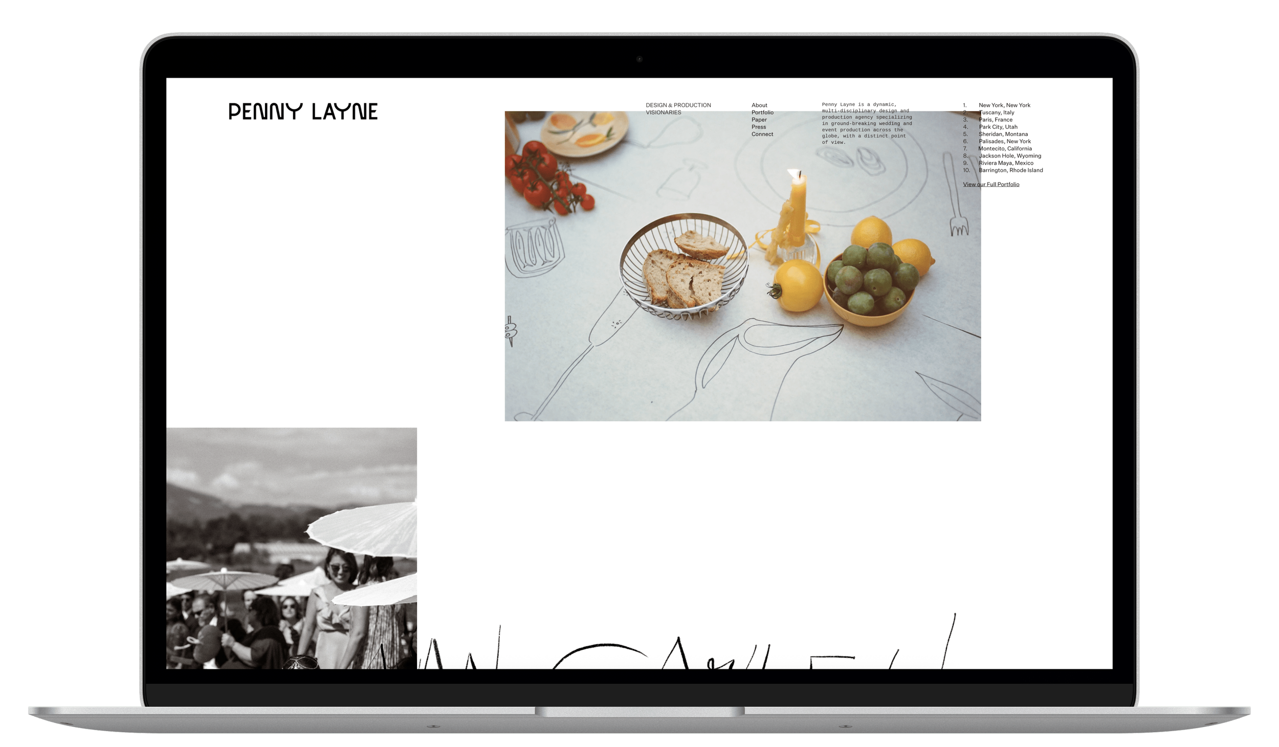 Laptop displaying a portfolio website with a photo of a still life with fruit, a candle, and bread on a table, and a black and white photo of people with umbrellas outdoors.