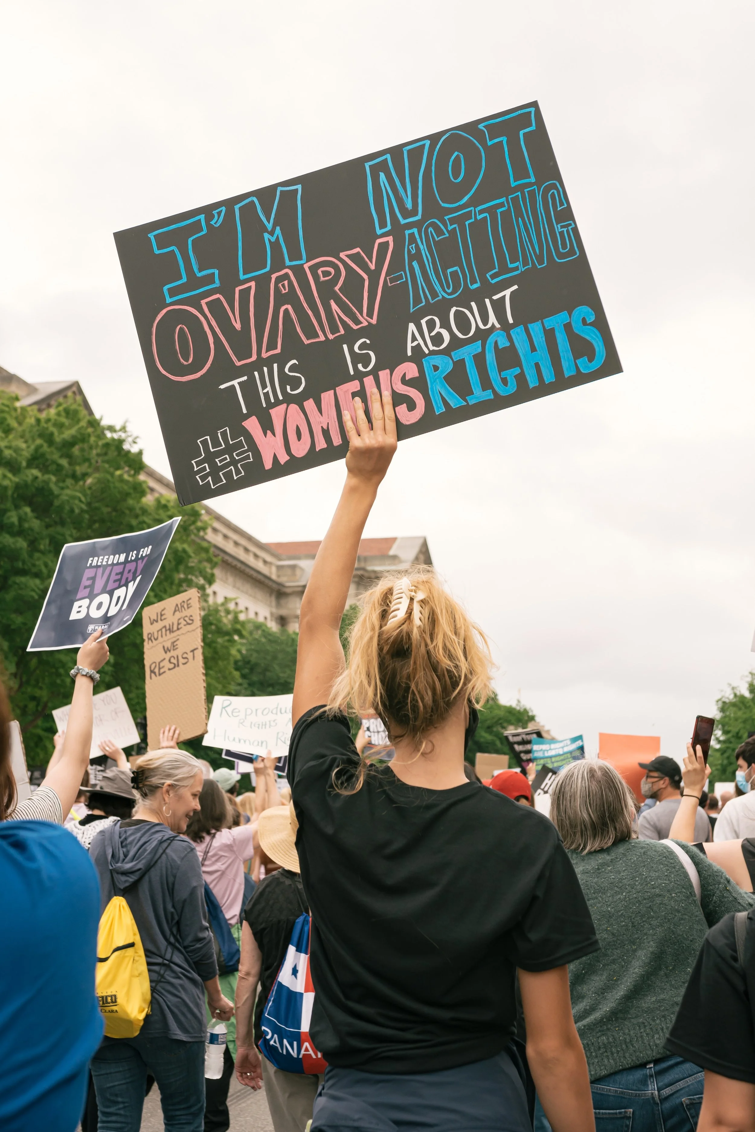 woman holding sign at protest for reproductive rights