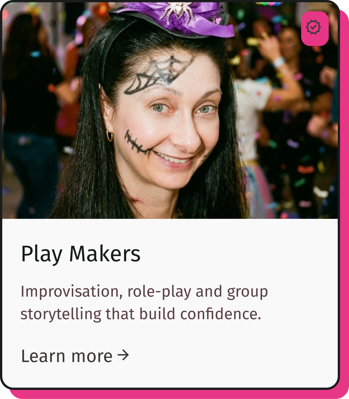 Woman with face paint and a purple hat at a crowded event.