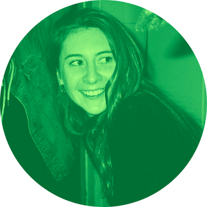 A woman smiling, with long hair, looking to the side, in a green-tinted circular photo.