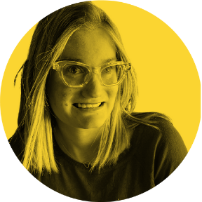 Portrait of a young woman with glasses smiling, against a yellow circular background.