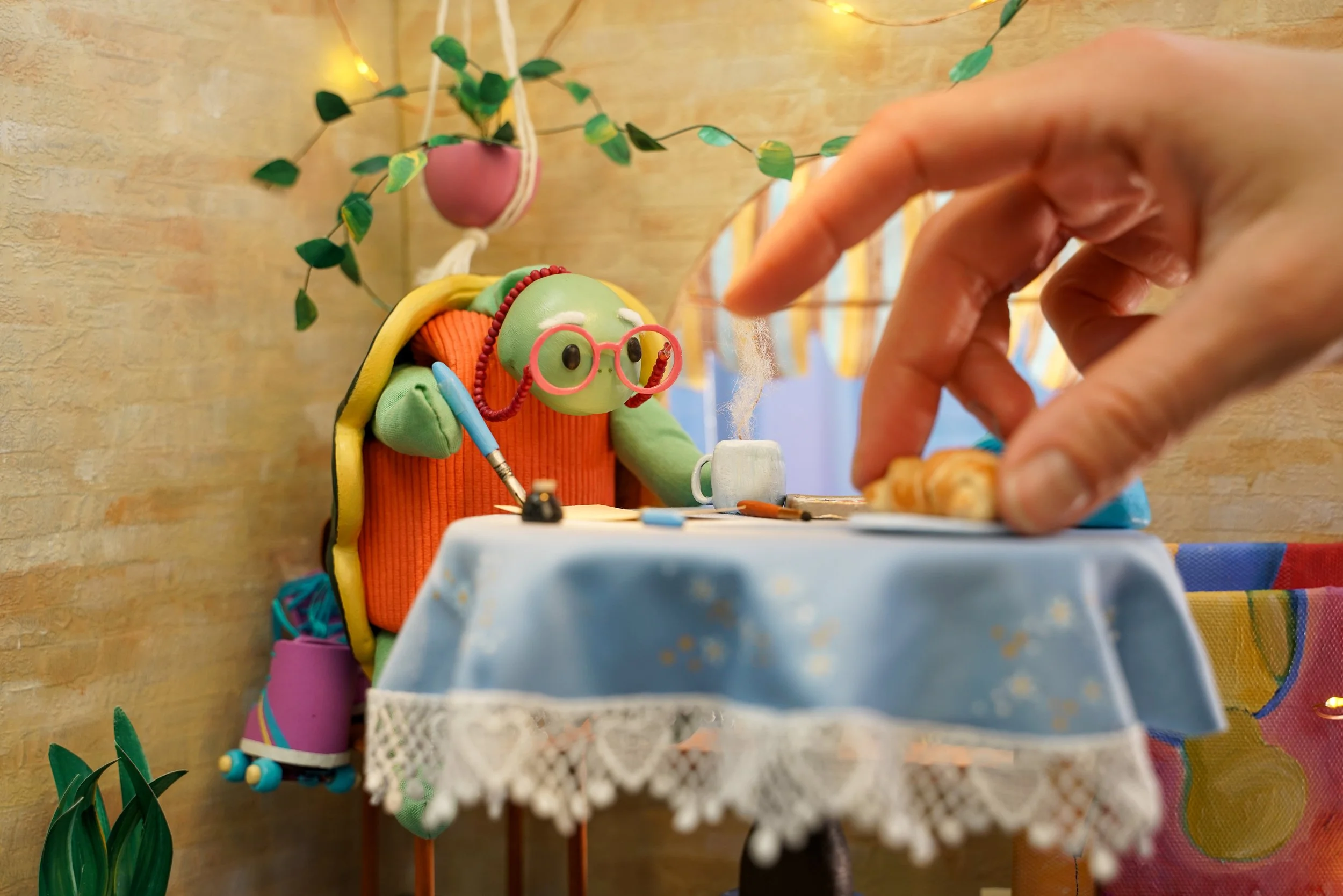 Grace Townley adjusts a handmade miniature croissant while photographing an illustration for the book, Slowly and Shirley.