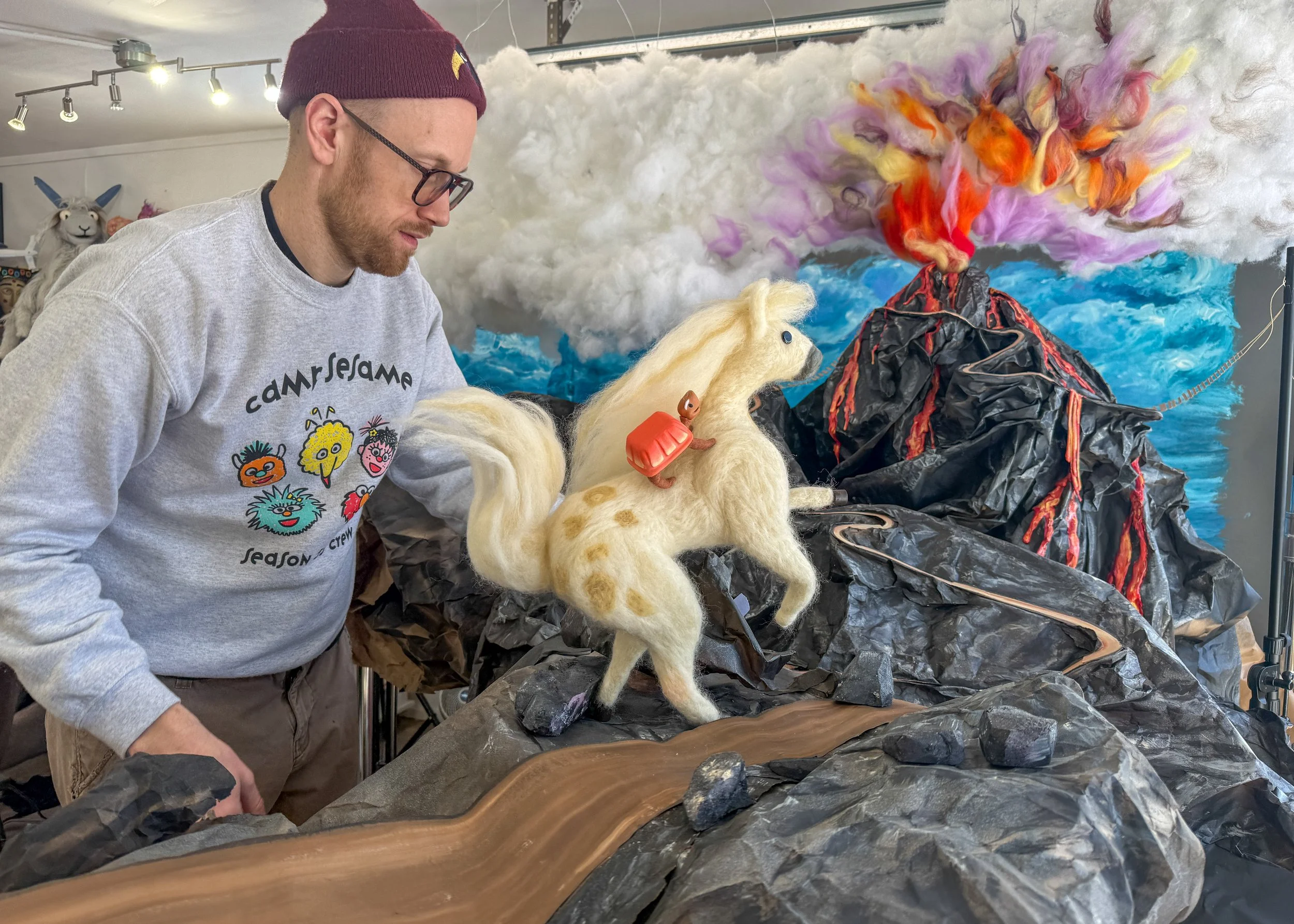 Behind-the-scenes photo setting up the illustration for Slowly riding up a volcano on a horse. Illustration from Slowly and Shirley, a book by Spencer Lott and Grace Townley, who built and photographed all the scenes and puppets.