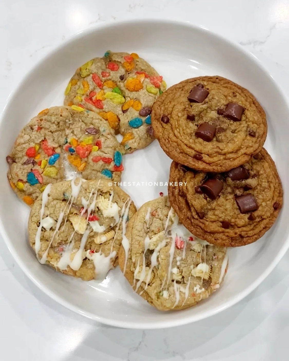 chocolate chip, fruity pebbles, bedrock cookies on a white plate in a circle