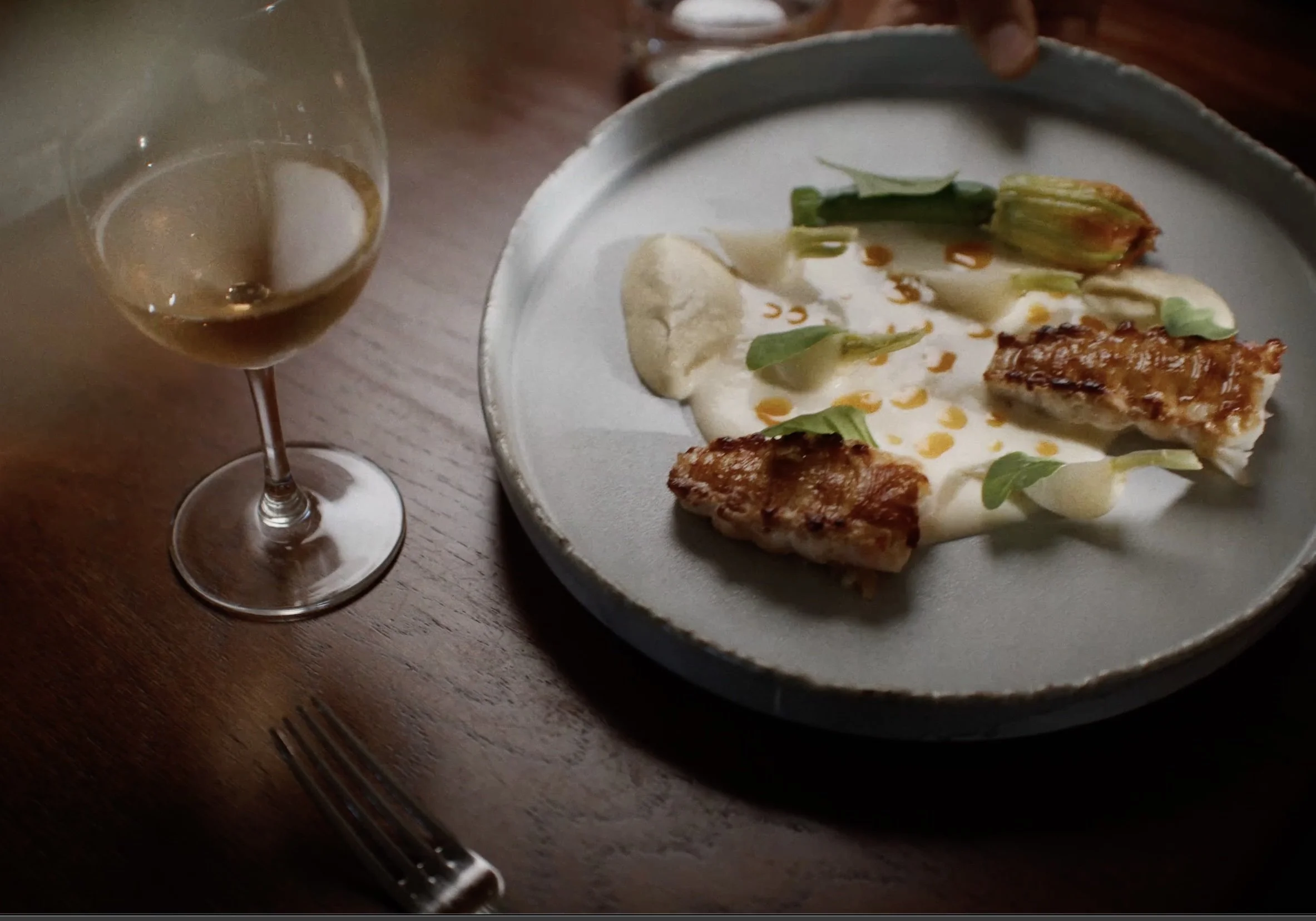 plate of food with lobster and vegetables and a glass of white wine
