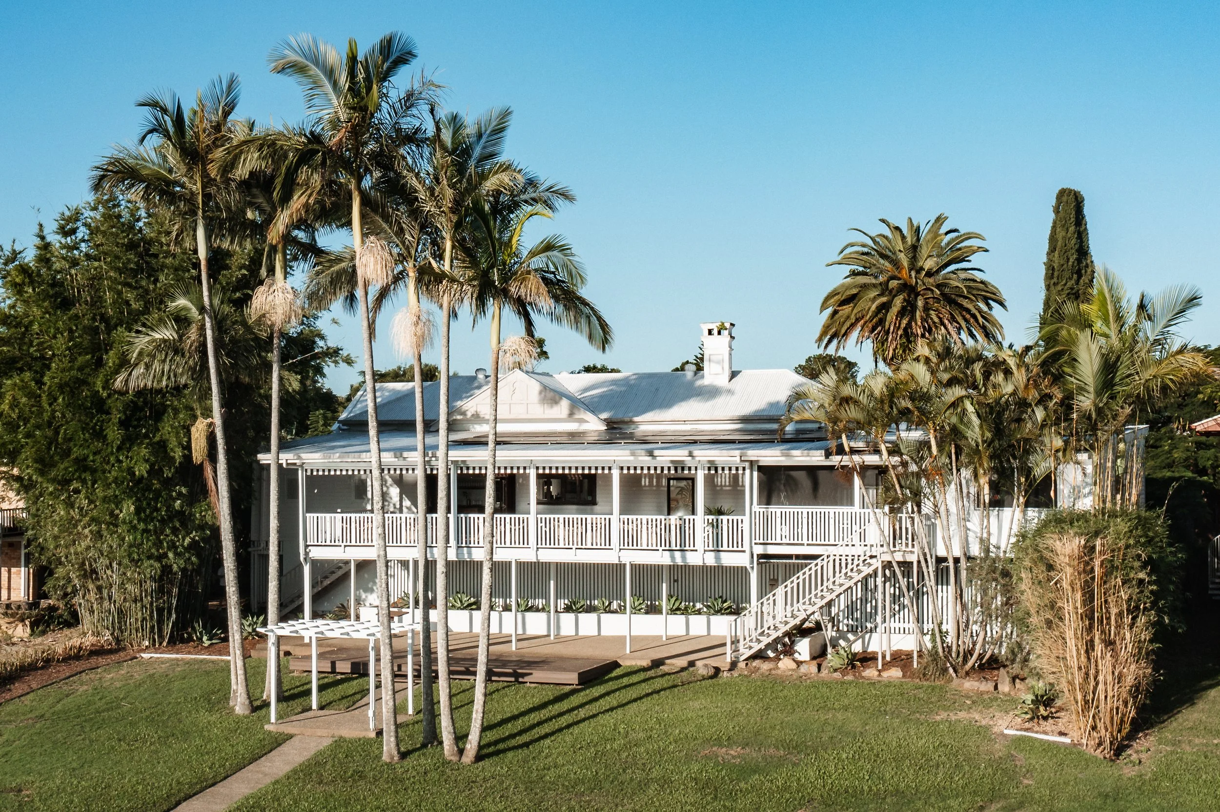tweed river house building with palm trees and gardens