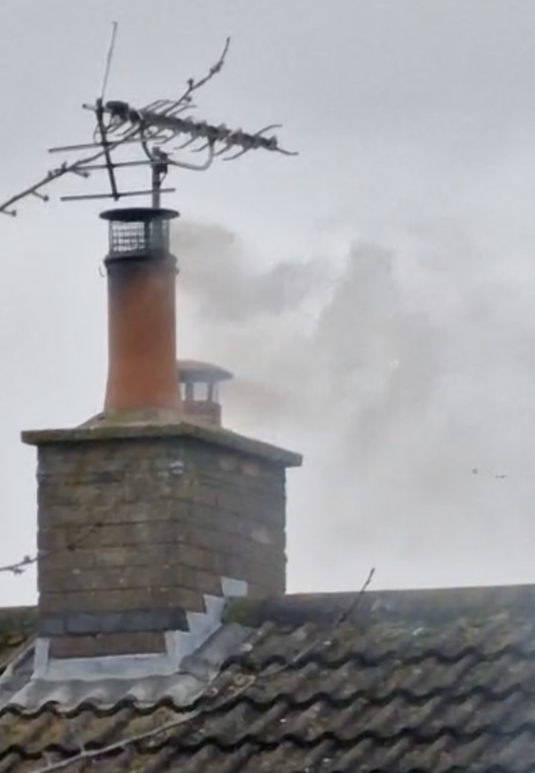 A chimney with a large cloud of smoke billowing out of it.