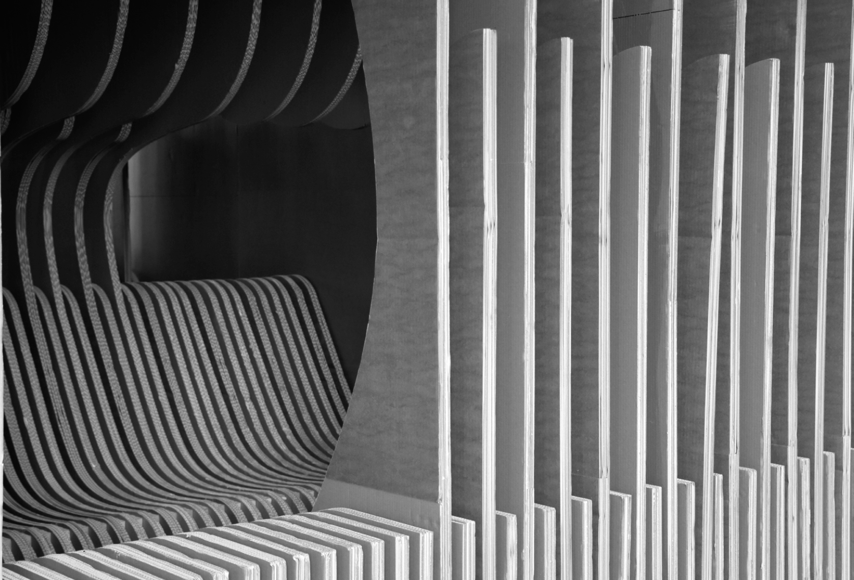 Modern interior design featuring curved black seating with striped fabric and horizontal wooden slats on a wall.