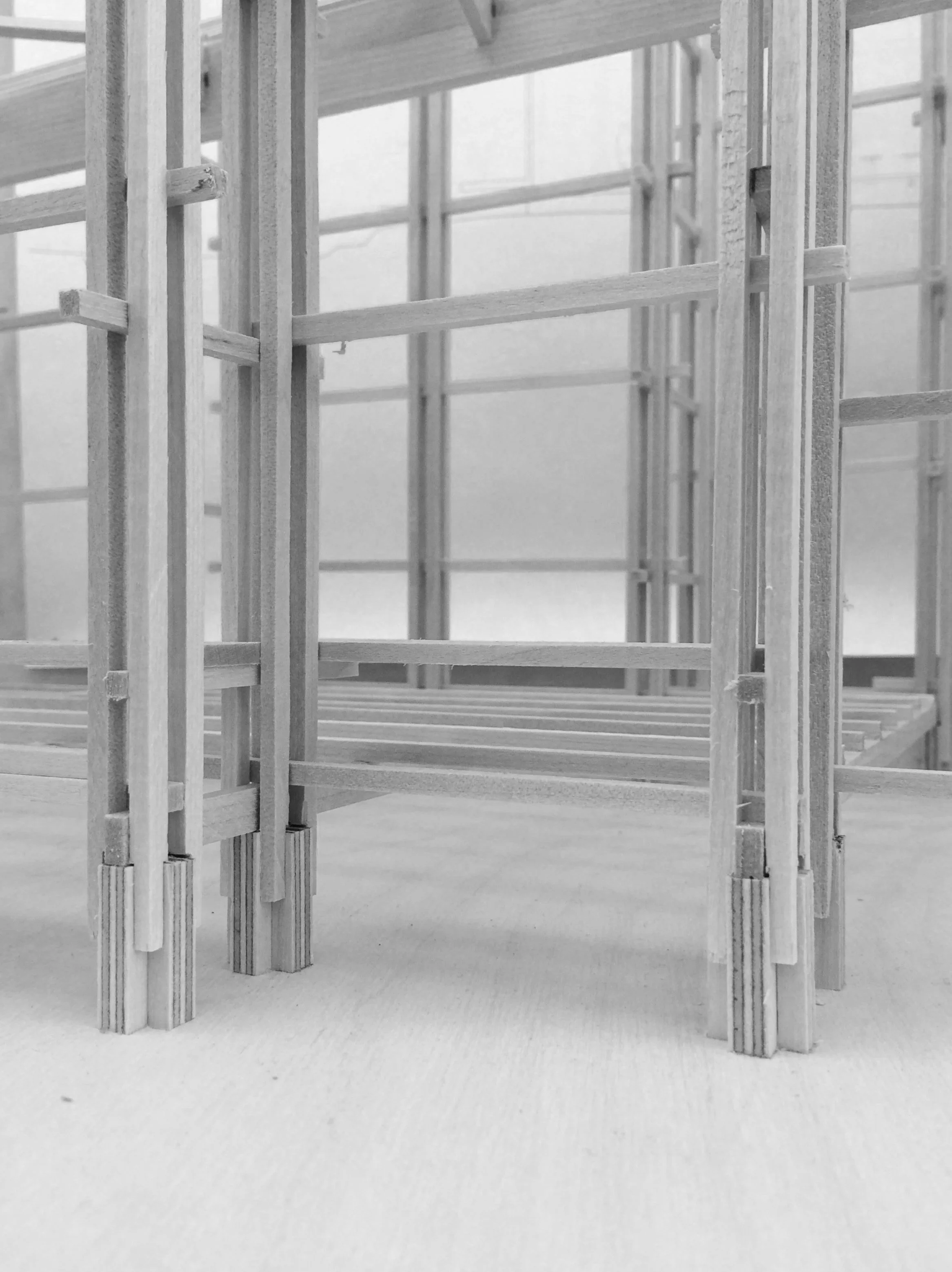 Close-up of a wooden structural framework, possibly part of a building under construction, with multiple vertical and horizontal beams.