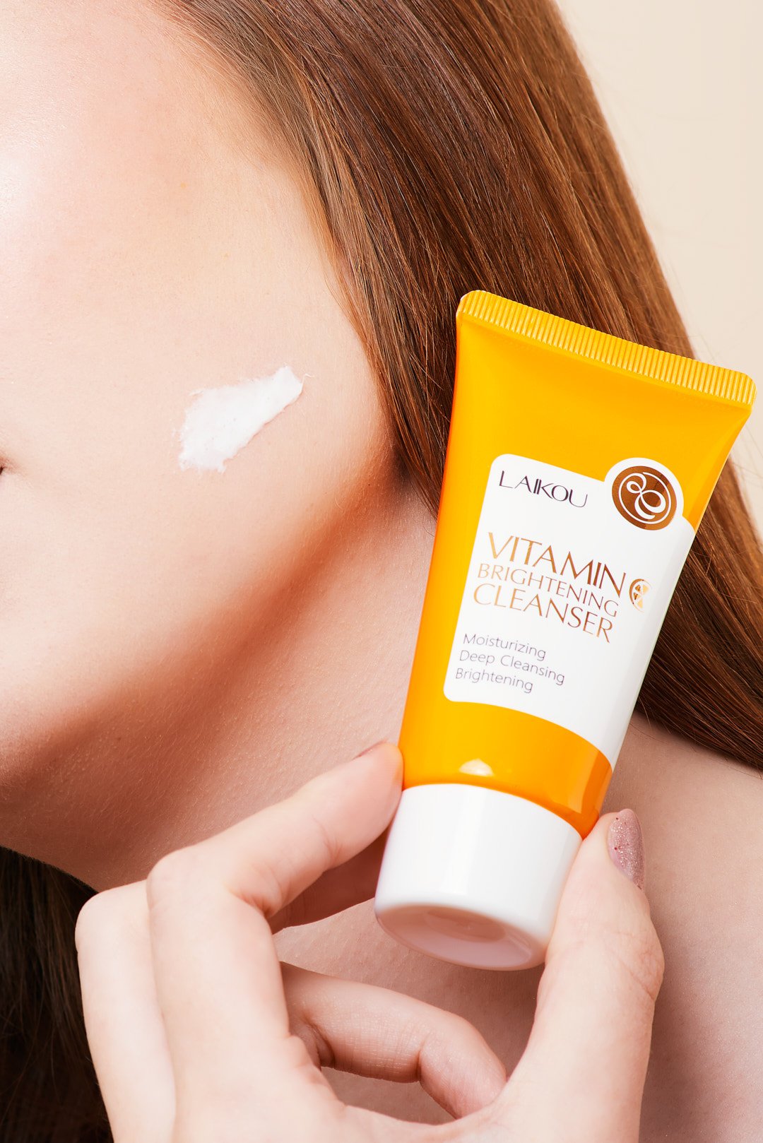 Person applying Laikou Vitamin Brightening Cleanser on cheek.