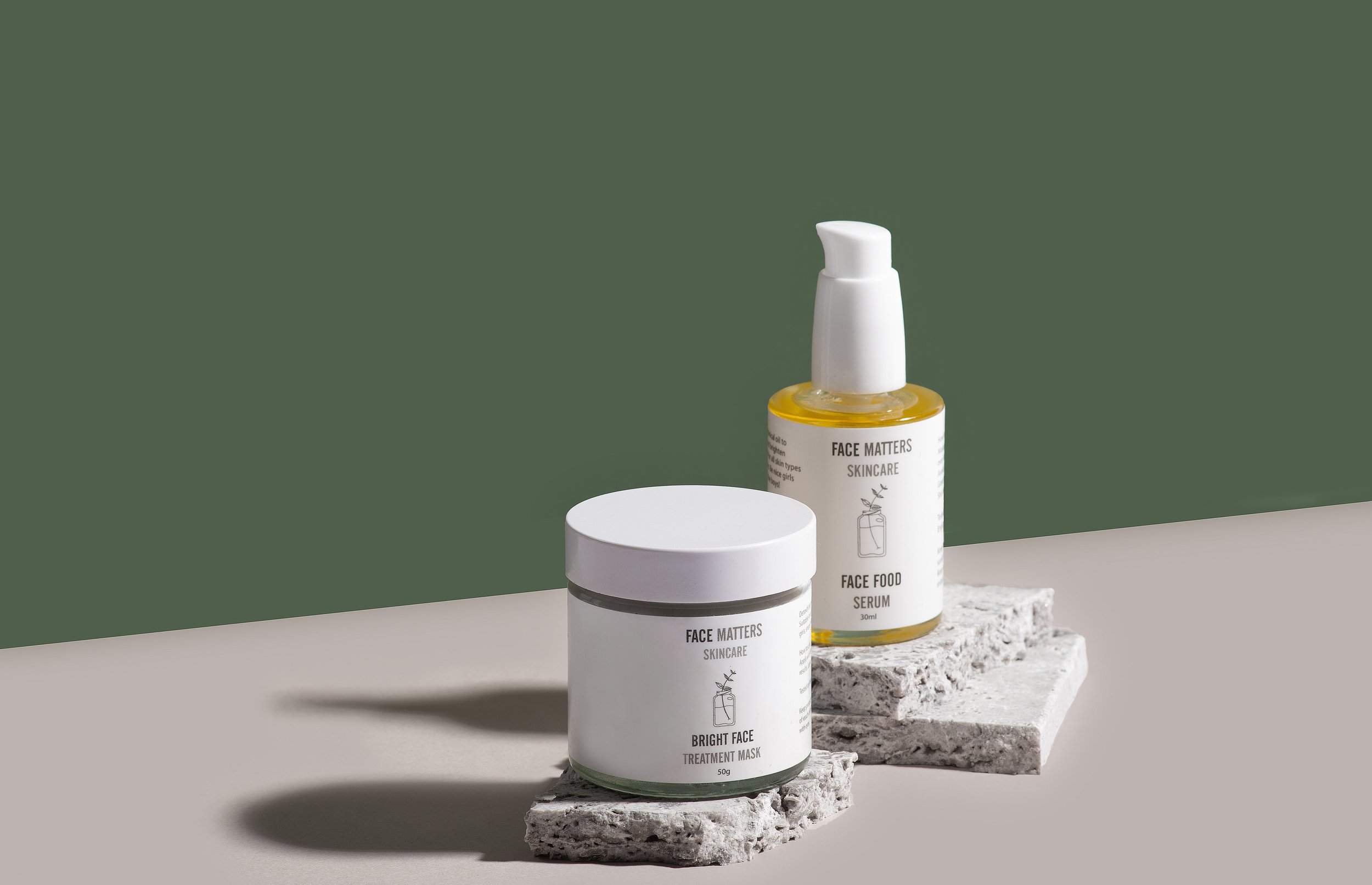 Skincare products on stone slabs, green background