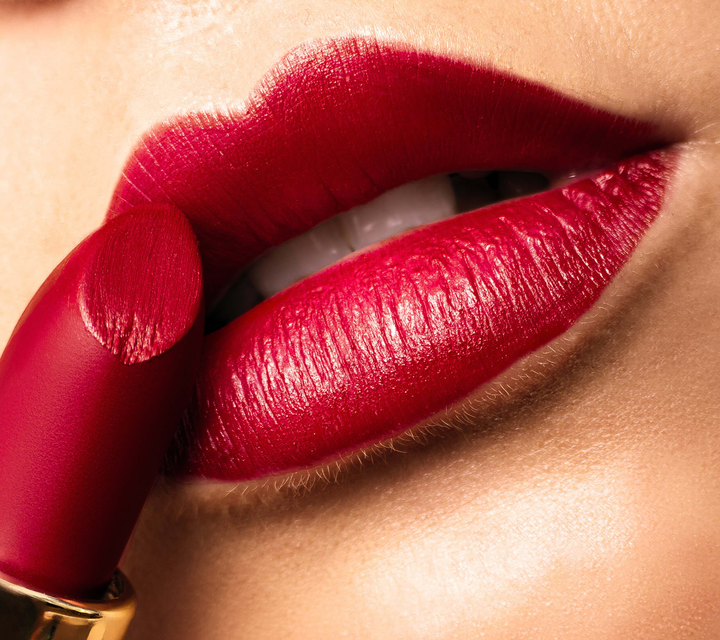 Close-up of lips with bright red lipstick being applied