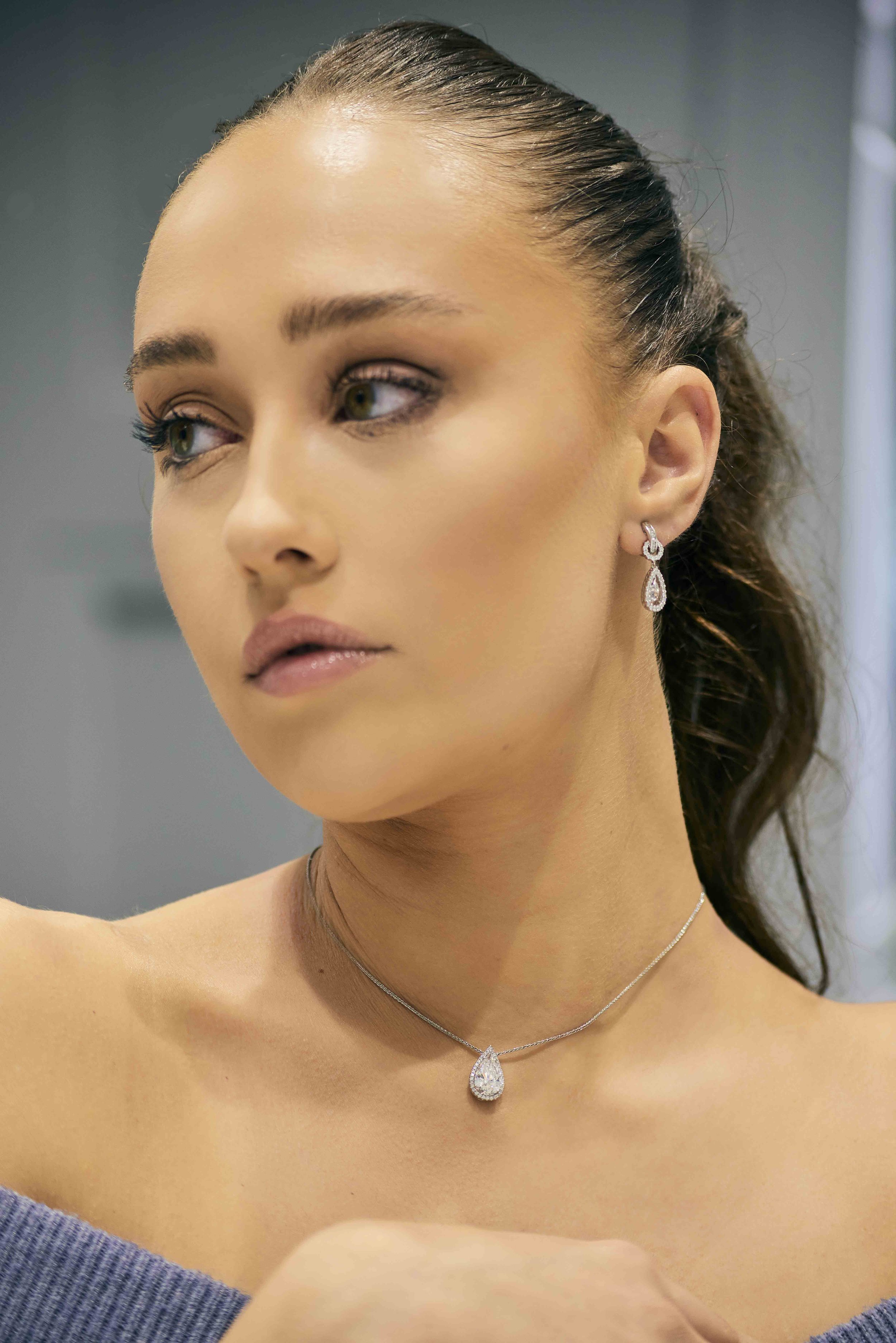 Woman wearing a teardrop diamond necklace and earrings