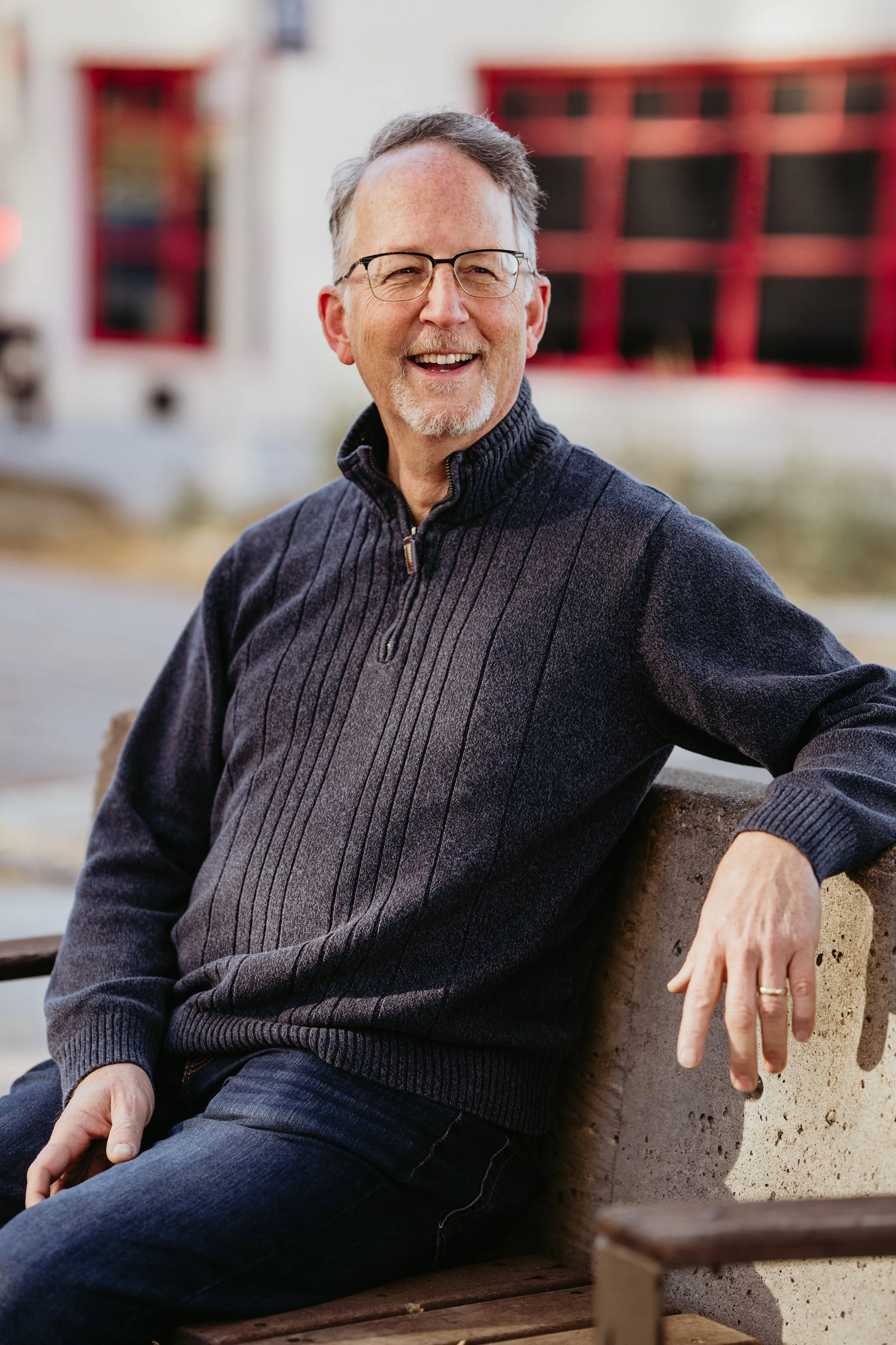 Smiling man sitting outdoors in casual, winter clothing