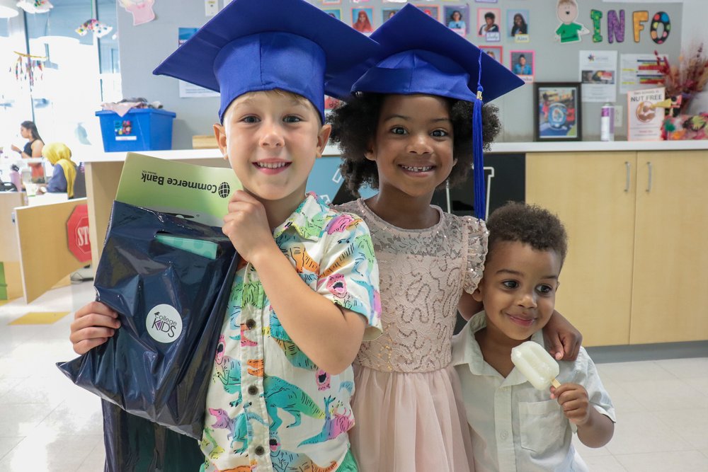 Graduates Anderson Wiggins and Ariah Williams posing with Kross Williams holding a goodie bag from St. Louis College Kids.