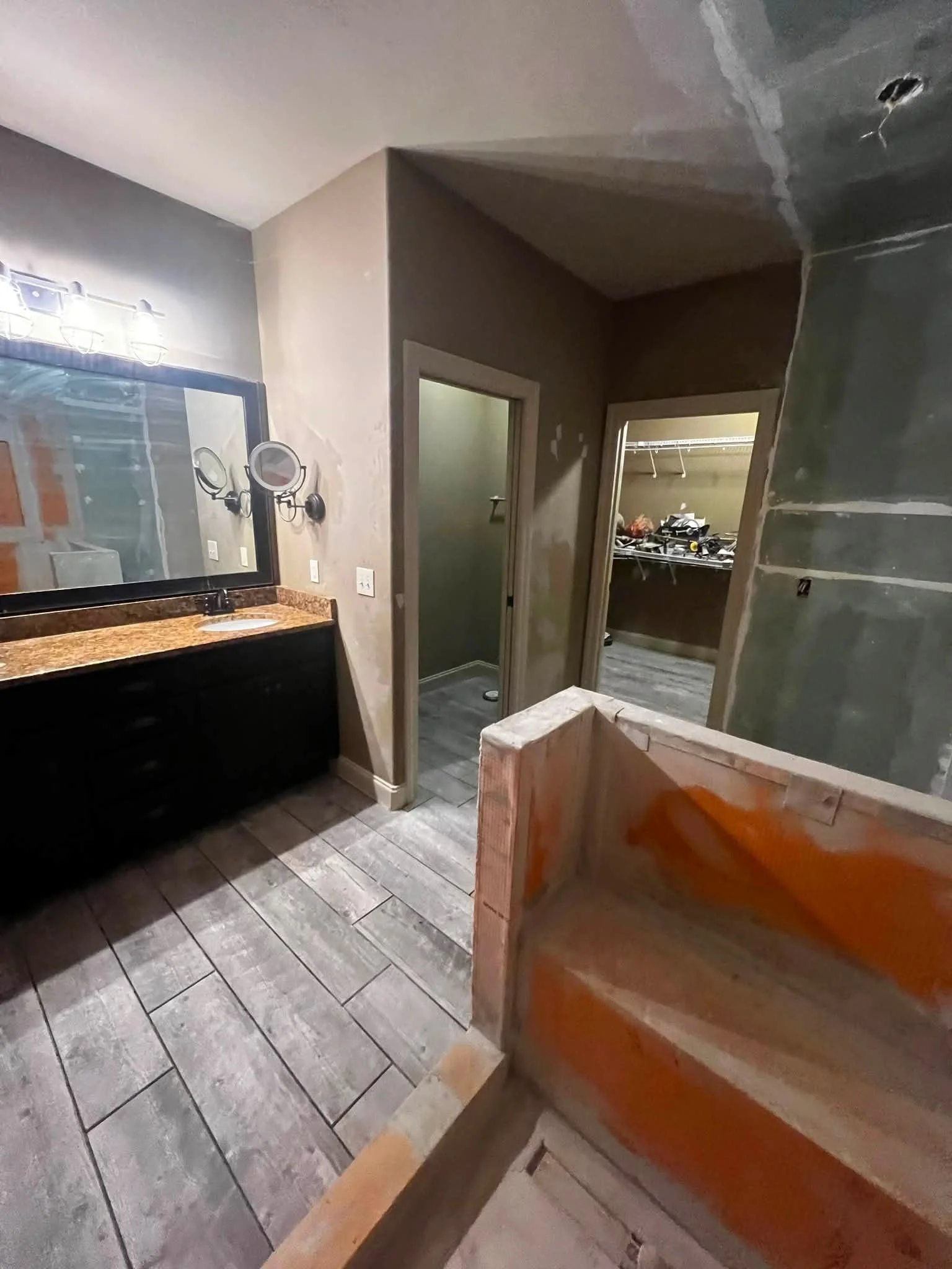 Interior of a room under renovation, with a partially constructed vanity and drywall in progress.