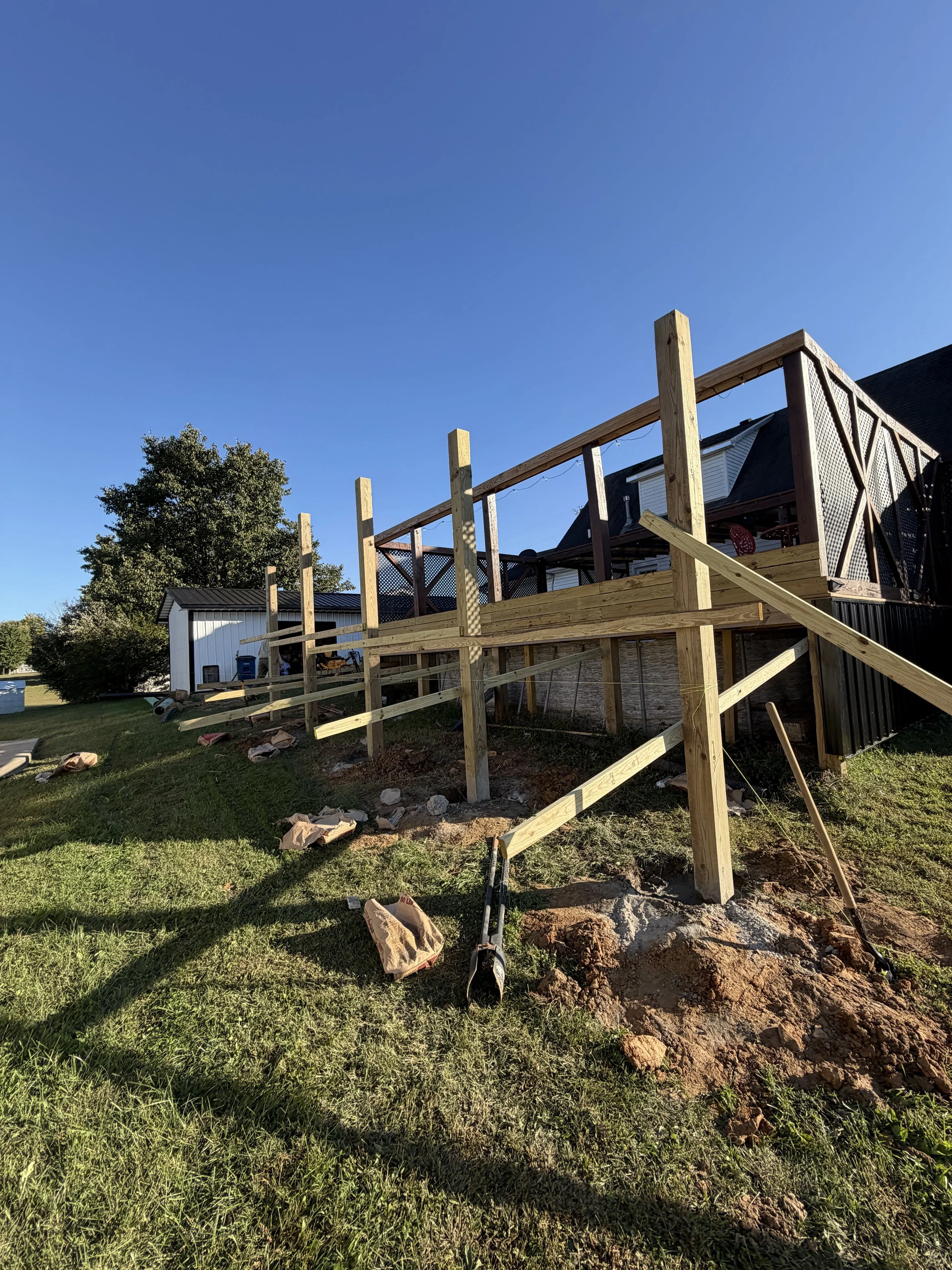 New deck posts set in concrete and leveled to an existing pool deck during a deck expansion in Leitchfield, KY