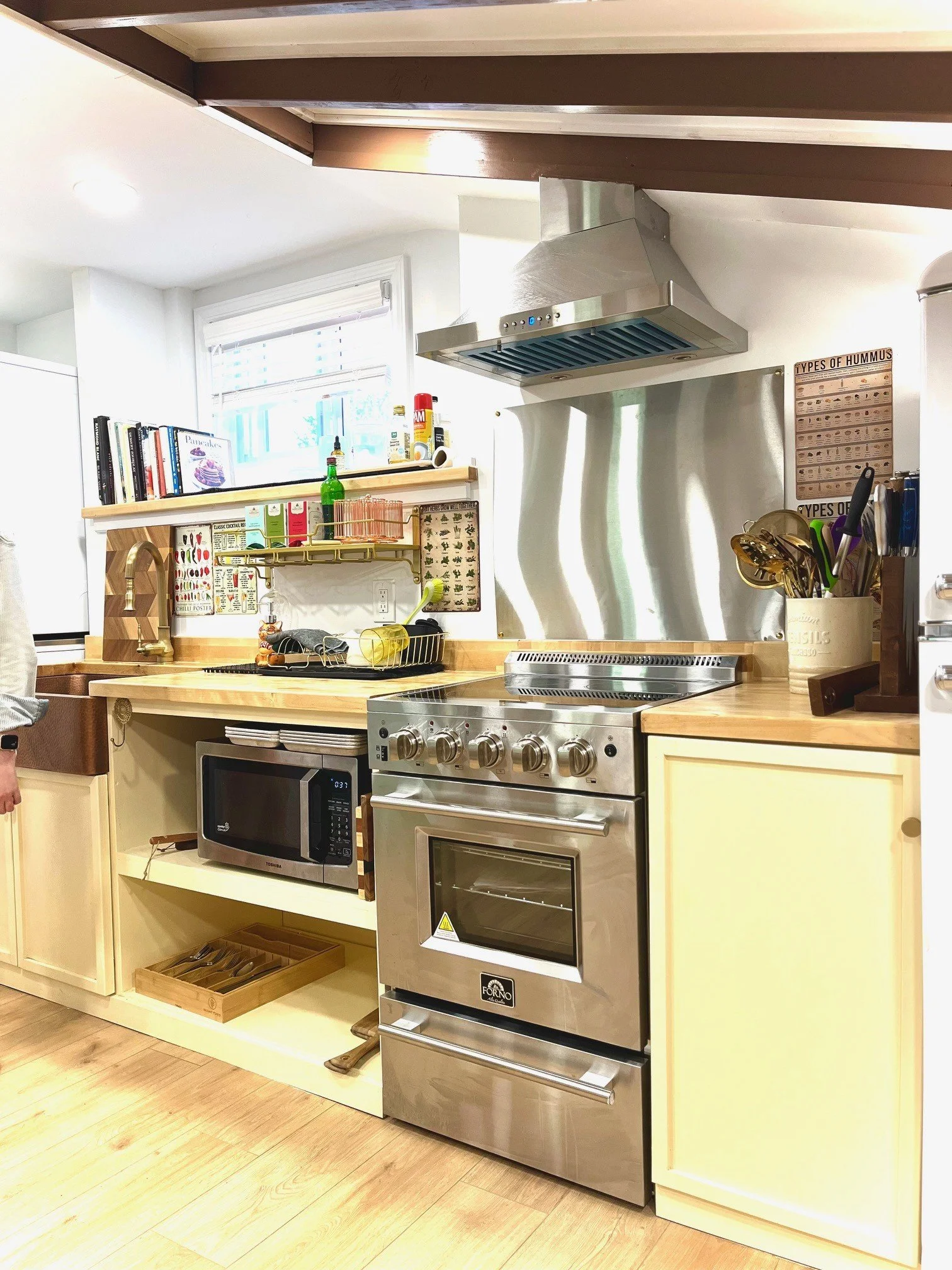 We love cooking in the custom kitchen; it’s such a joy to work in! Painted in warm golden hues, it features a sleek stainless steel stove and oven, and the spacious copper farmhouse sink provides plenty of room to work comfortably.