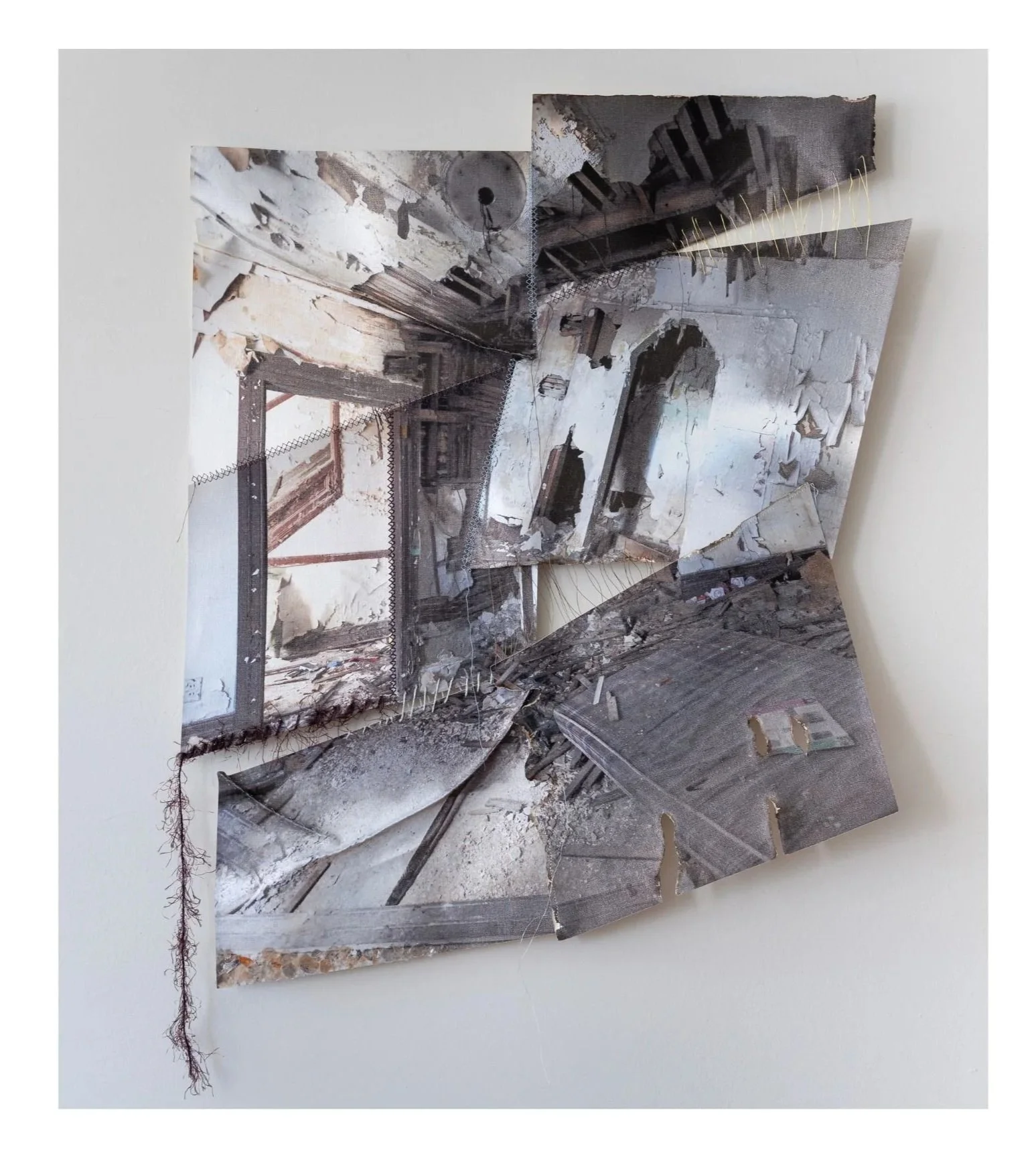 A collage of fragmented photographs depicting the interior of a dilapidated building, with torn pieces overlapping and some threads hanging from the edges.