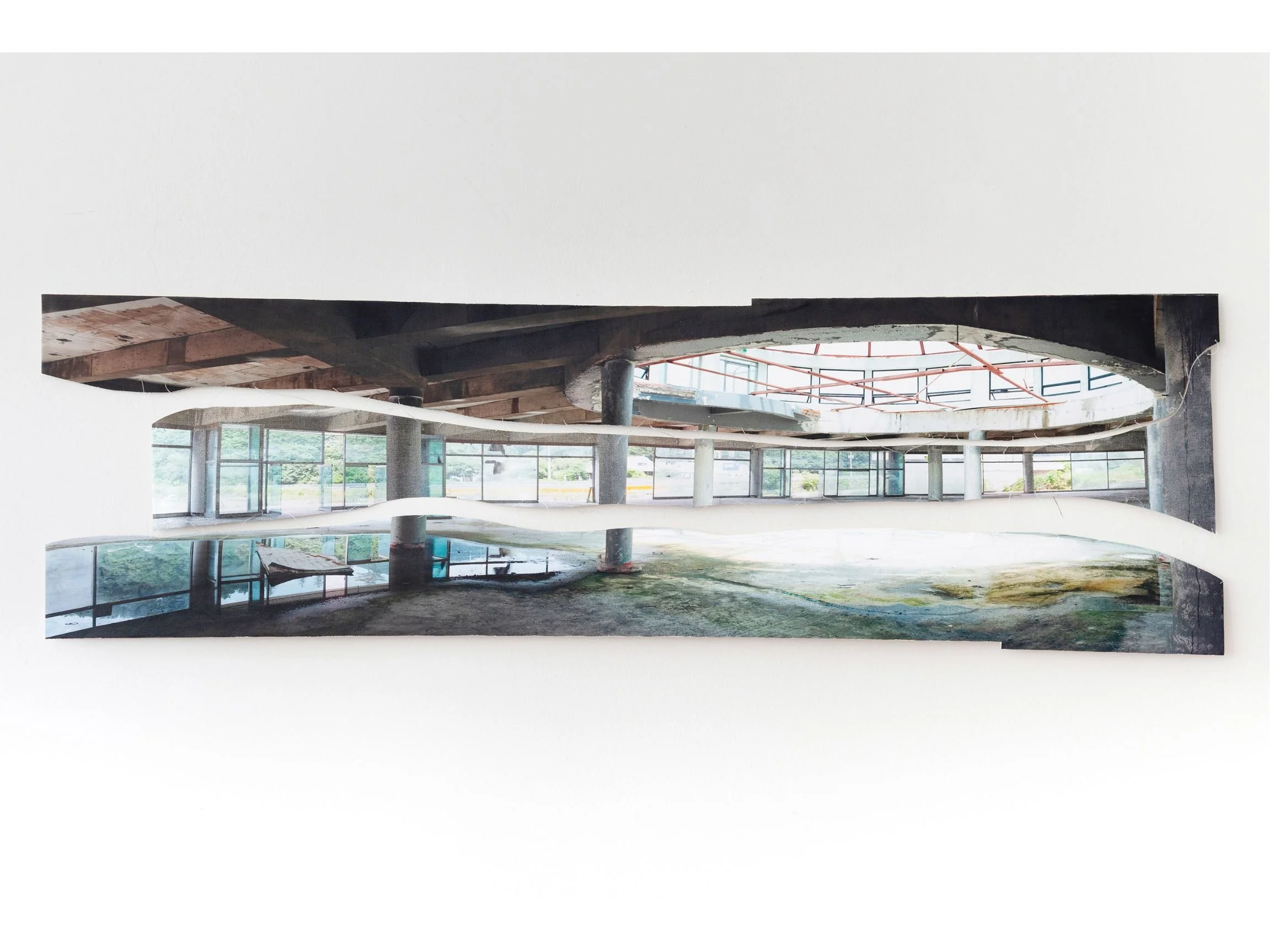 Panoramic photographic collage depicting the interior of an unfinished or abandoned building with concrete columns, large windows, and an oval opening in the ceiling. The image is composed of layered horizontal strips with visible cut edges, showing 