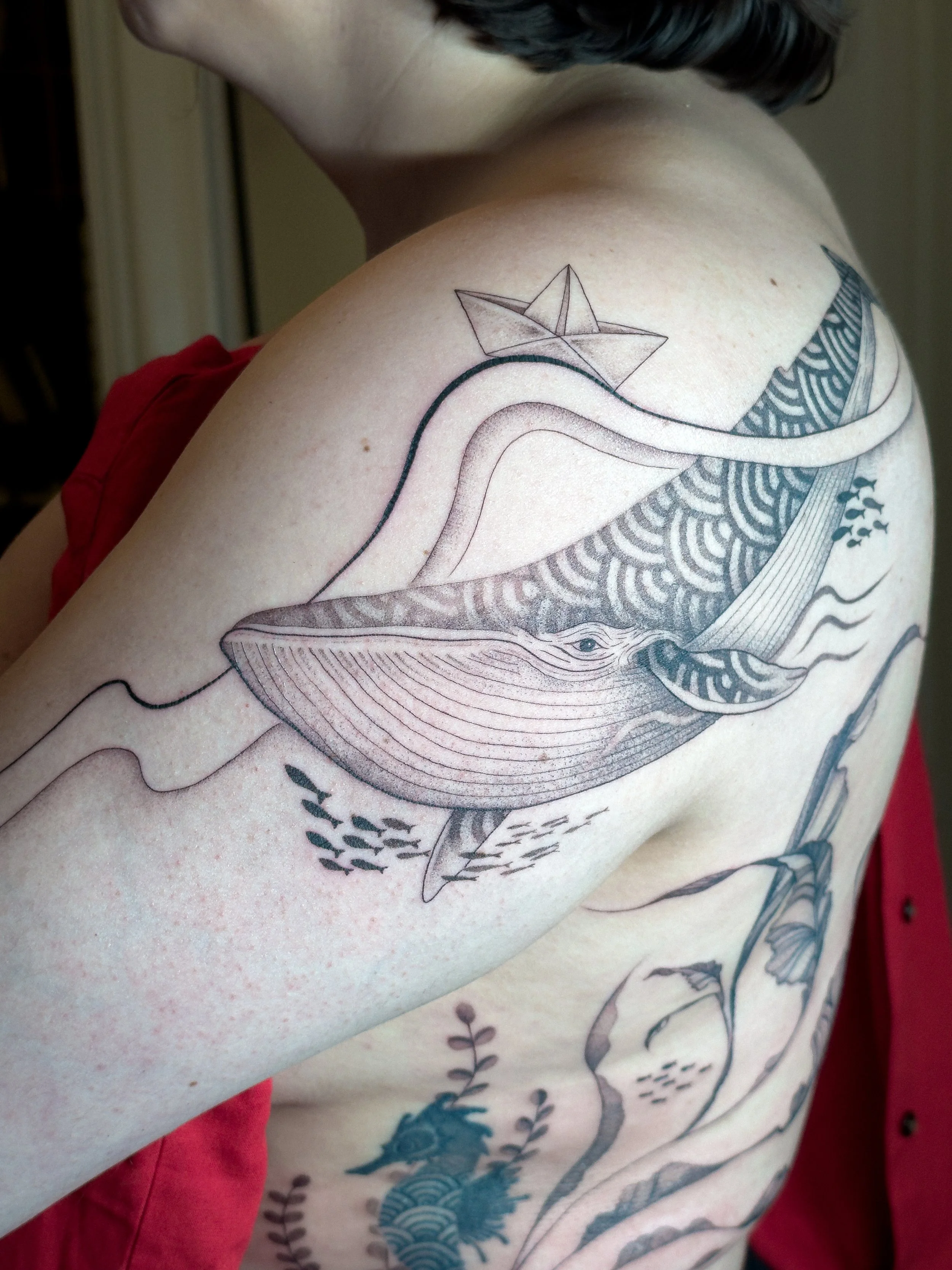 Flowing fine line tattoo inspired by marine life, featuring a whale, organic lines, and botanical ocean elements. Designed to move naturally with the body, creating a soft and cohesive composition across the back and side.

Custom tattoo by Lis Roldá