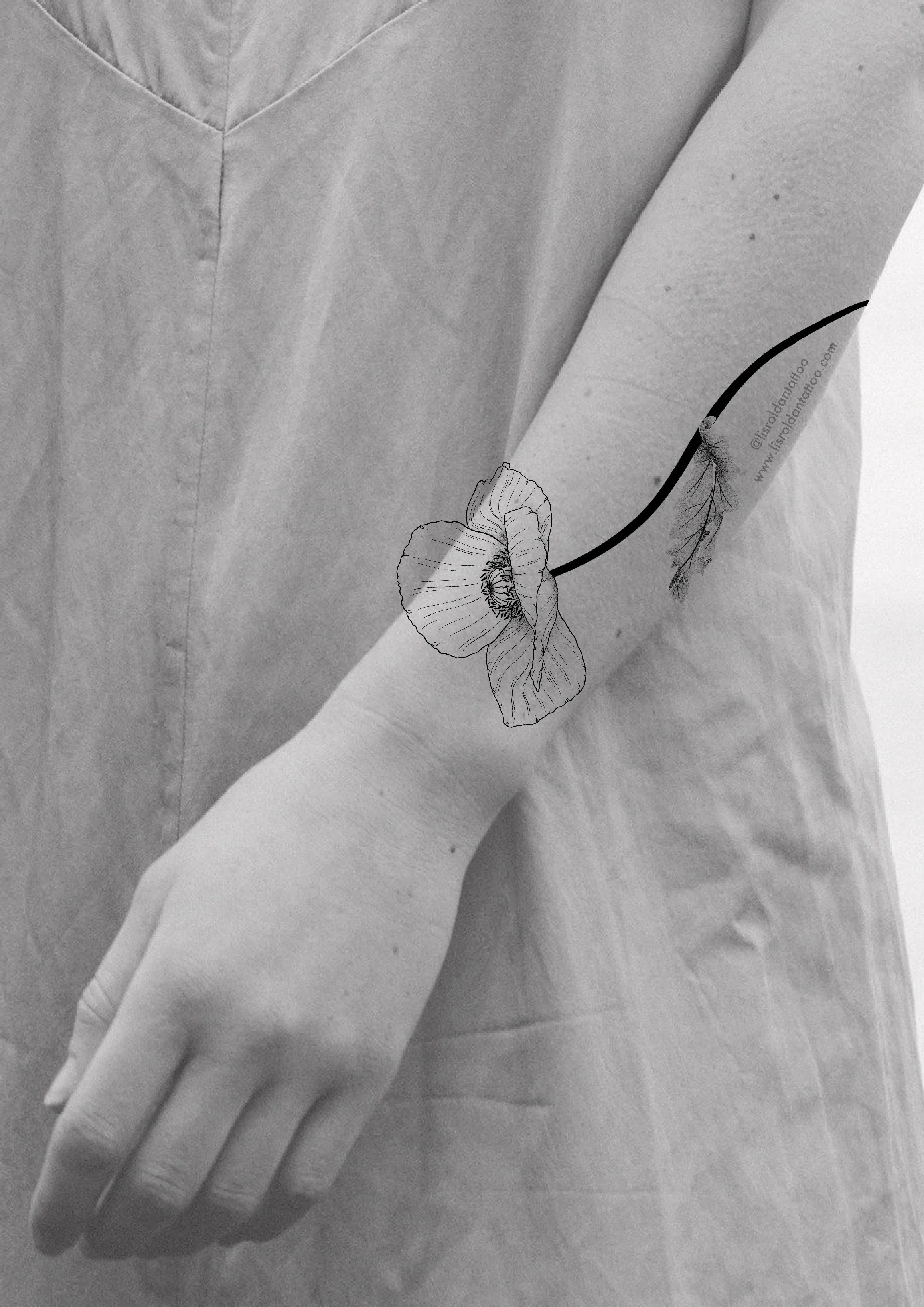 Minimalist forearm tattoo design by Lis Roldan featuring a delicate poppy flower in fine black lines, paired with a bold, flowing stem that follows the natural curve of the arm. The soft, paper-like petals contrast with the clean stem, creating a har