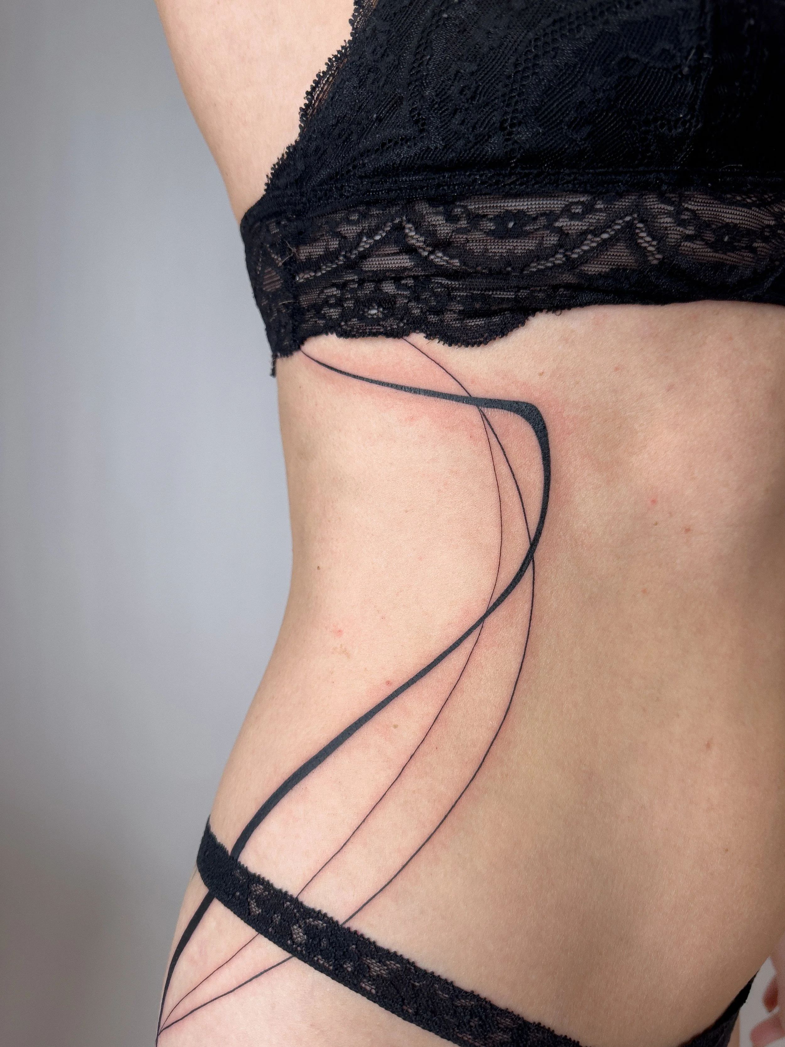 Freehand fine line tattoo with flowing lines designed to follow the natural curves of the body. A minimal and elegant composition that enhances movement and body flow.

Custom tattoo by Lis Roldan.