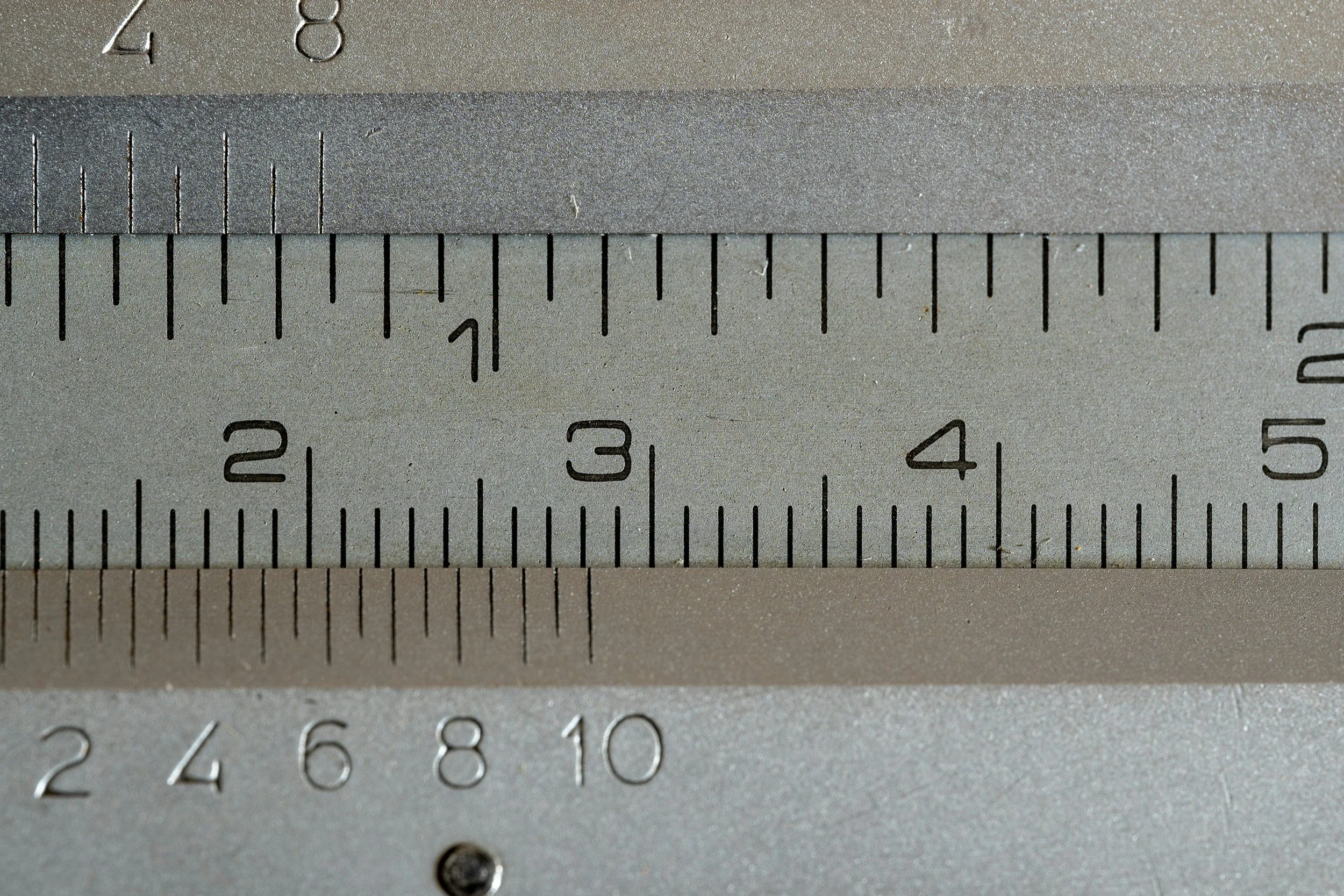 Close-up of a metal ruler with measurements in inches, showing measurements from about 2.5 to 5 inches.