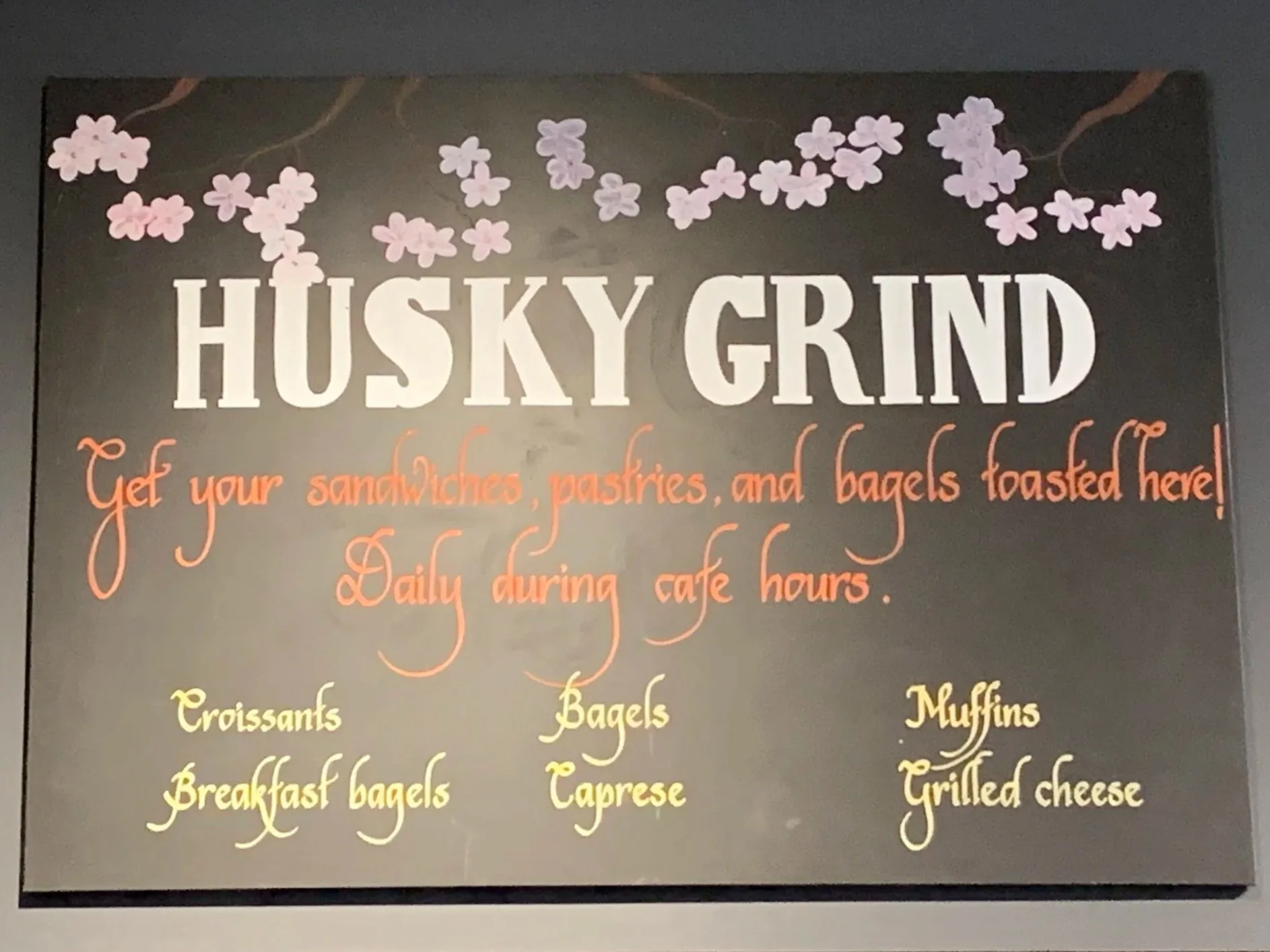 Hand-crafted menu board design for Husky Grind café, combining floral illustration and expressive typography for a warm, artisanal brand feel.