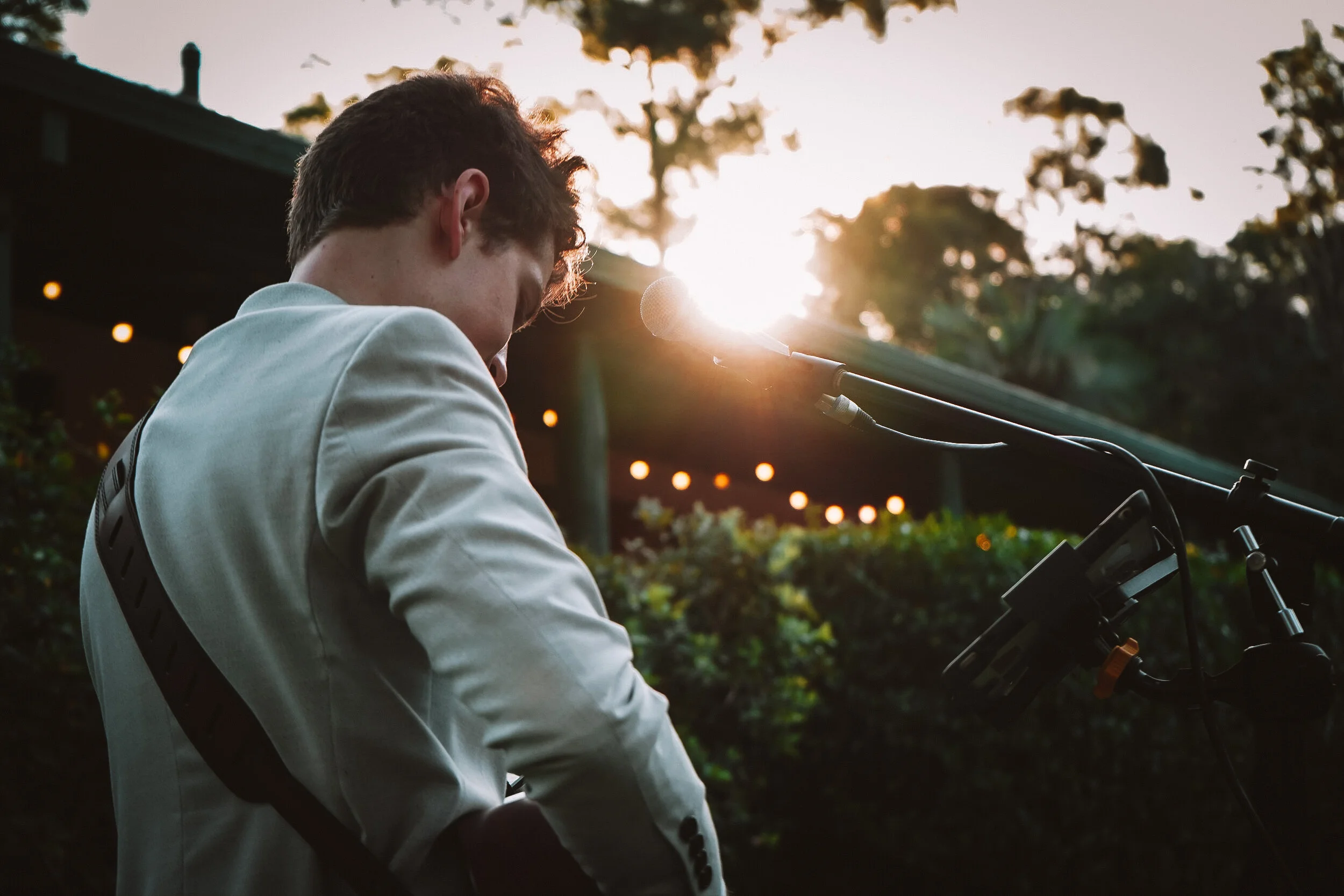 A young man playing live music at a wedding during canapé hour
