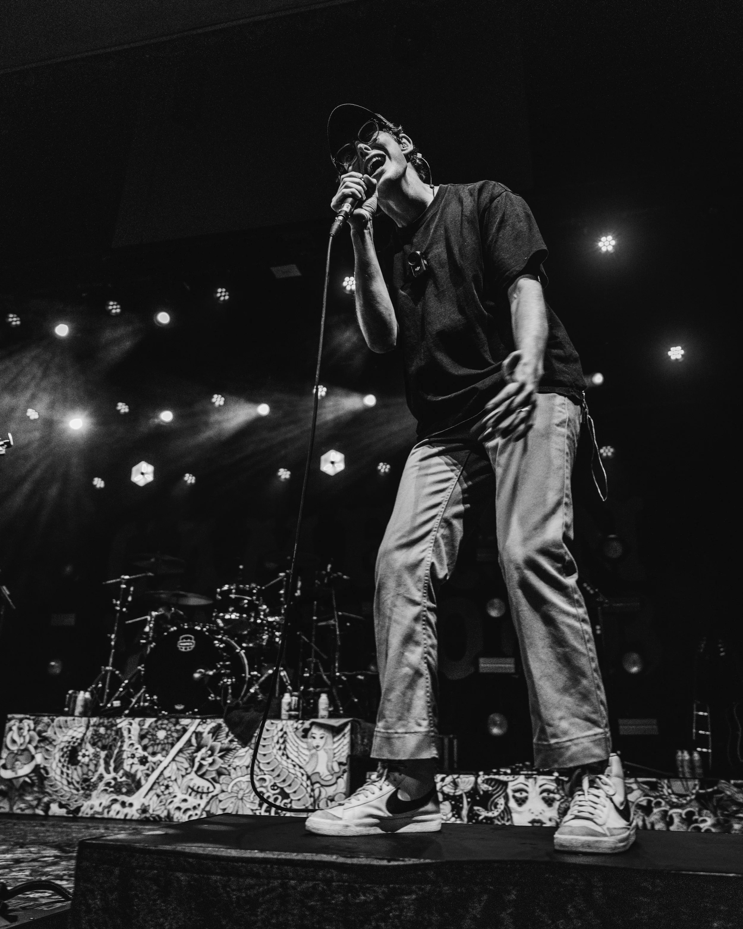 Musician singing on stage at a live show to a crowd of people