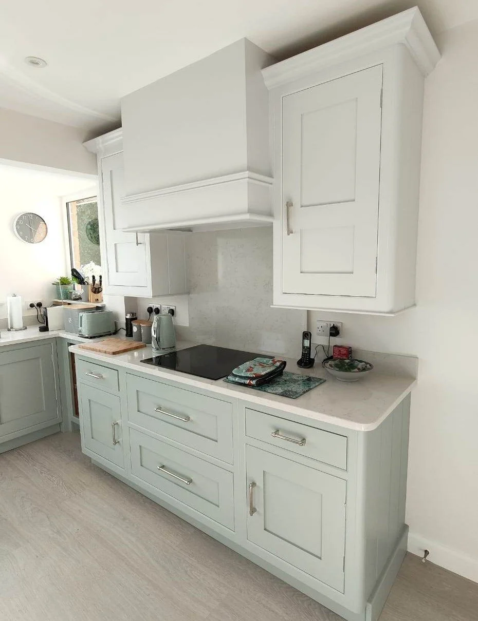 Clean, light-colored kitchen with cabinets, countertop, and appliances.