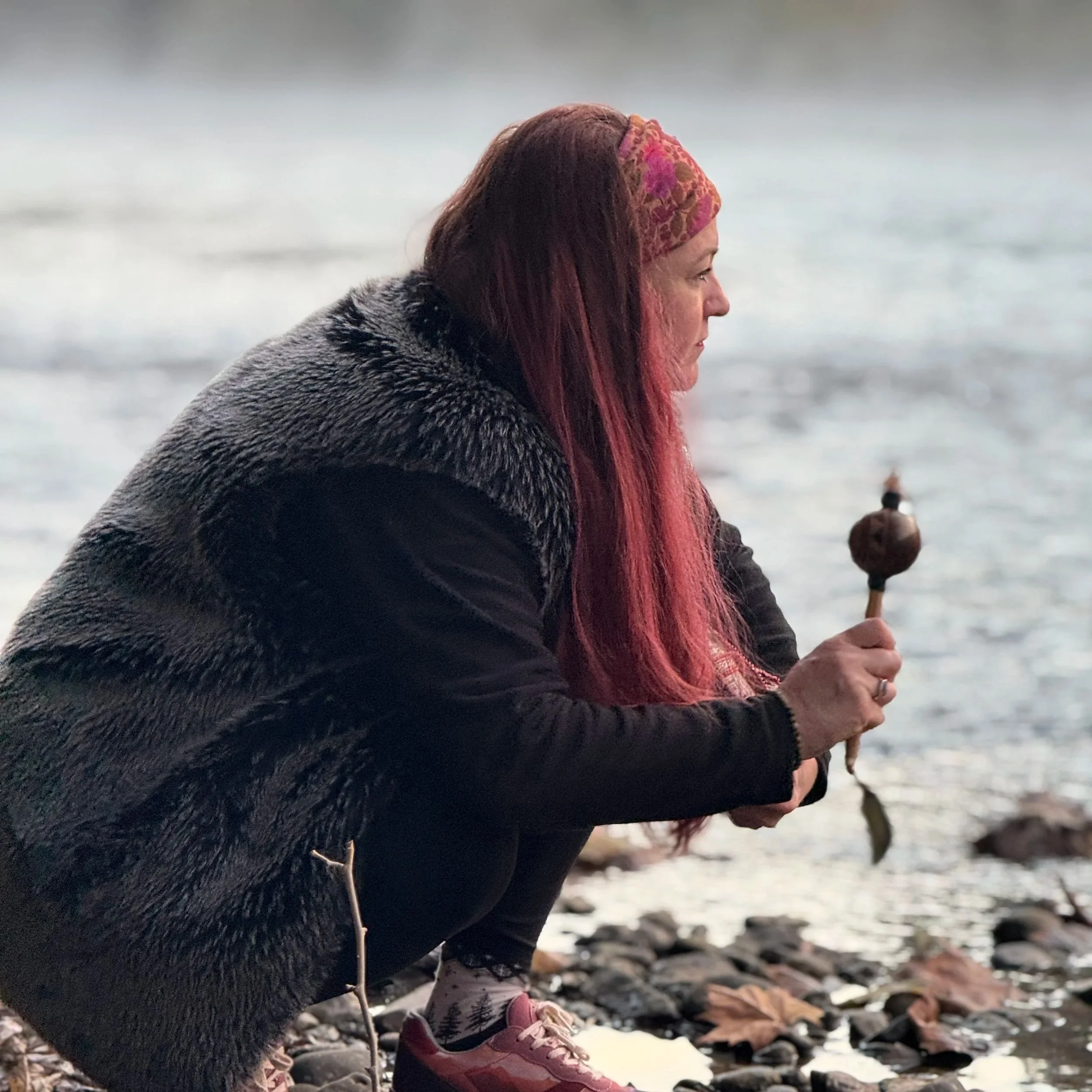 Angela by the river with her shaman's rattle.