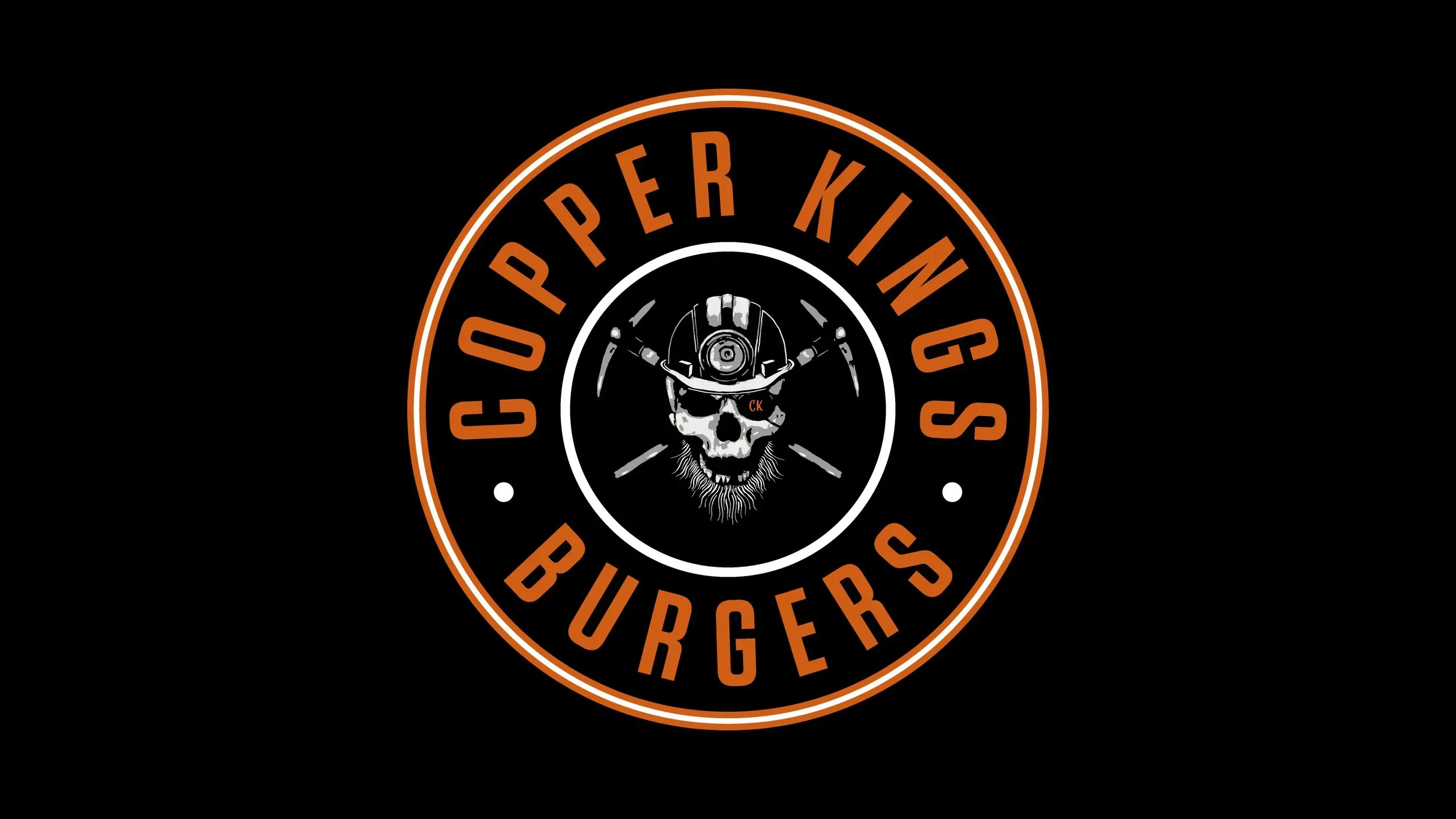 Logo for Copperper Kitchens Burgers featuring a skull wearing a helmet with motorcycle handlebars, with the text "Copperper Kitchens" arched above and "Burgers" below.