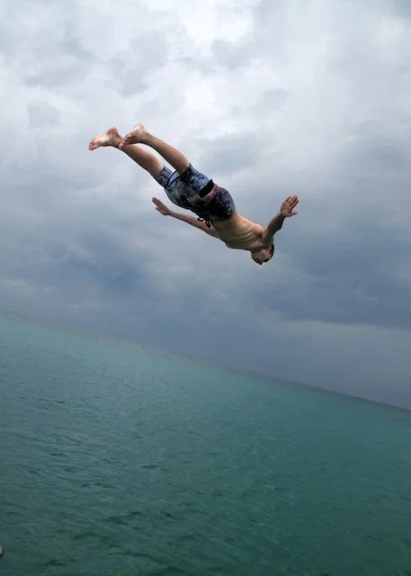 ethan dives from the top of the boat