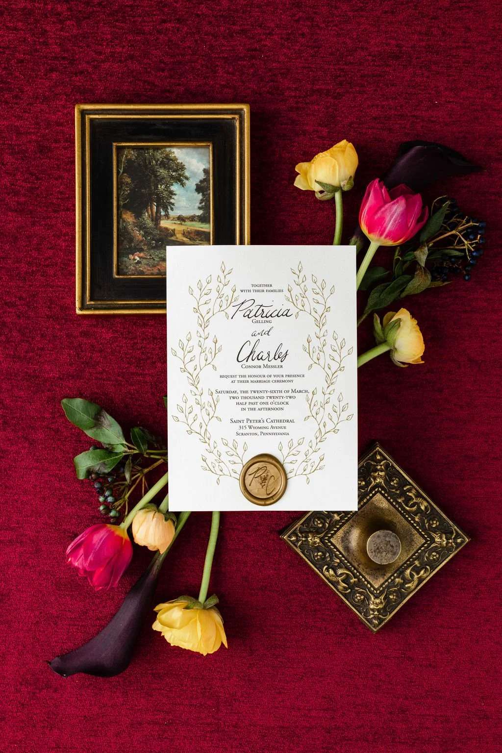Gold laurel frame wedding invitation with wax seal.