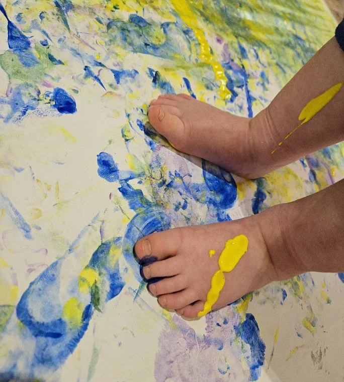 preschool feet covered in yellow and blue paint