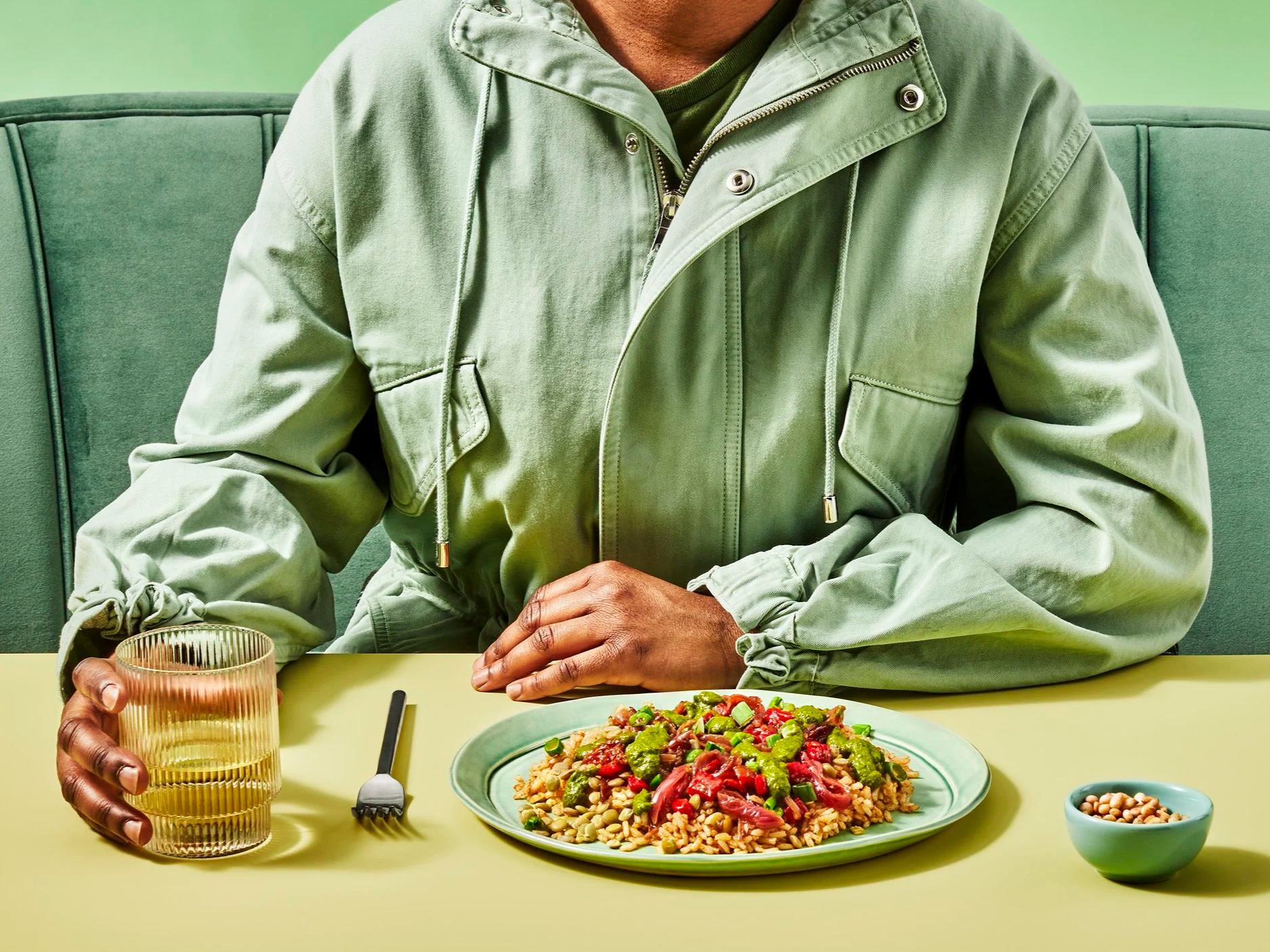 Factor_ meal delivery person in green jacket sitting with plated meal