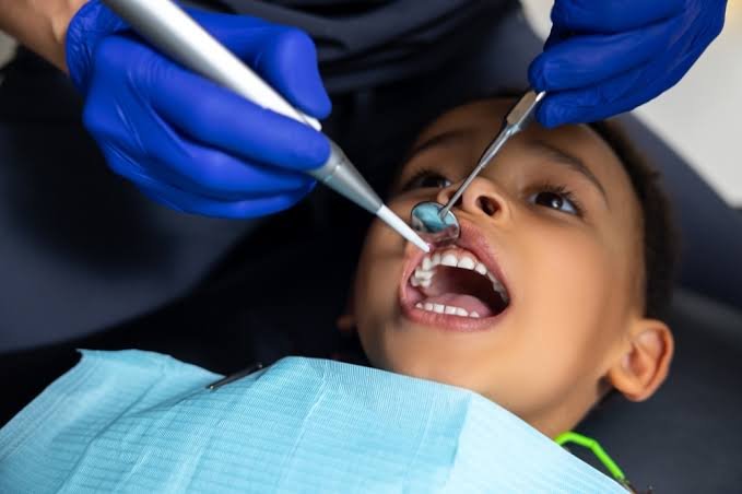 Pediatric dentist examining a child’s teeth at a dental clinic in Dubai.